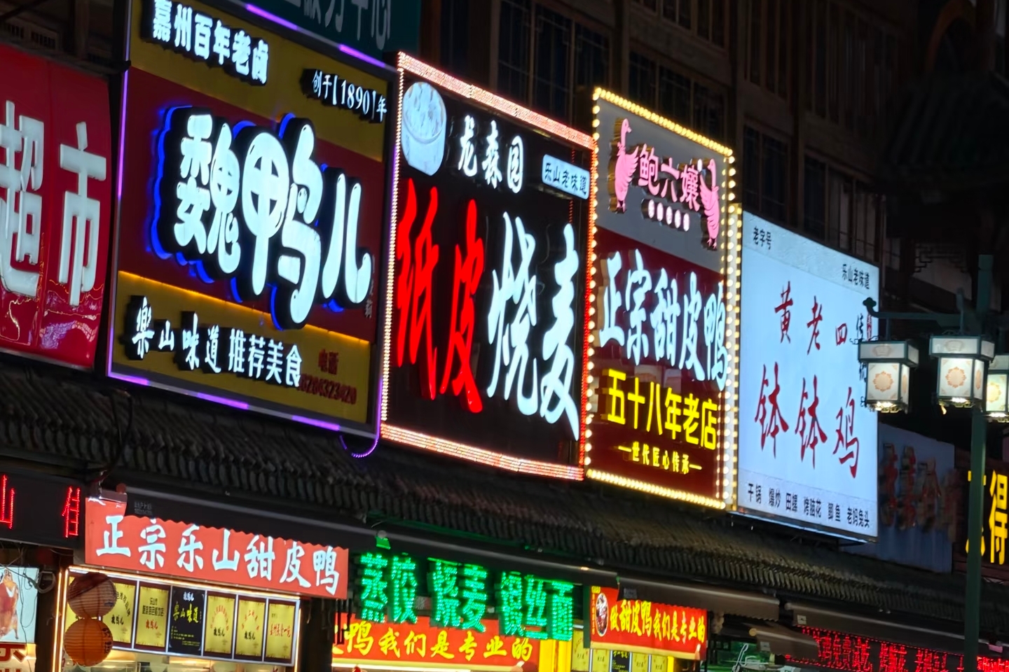 樂山張公橋美食街燈火璀璨，各色甜皮鴨特色店鋪招牌林立，滿是地道川味菸火氣。（2-8人小團去，巴士團不去）