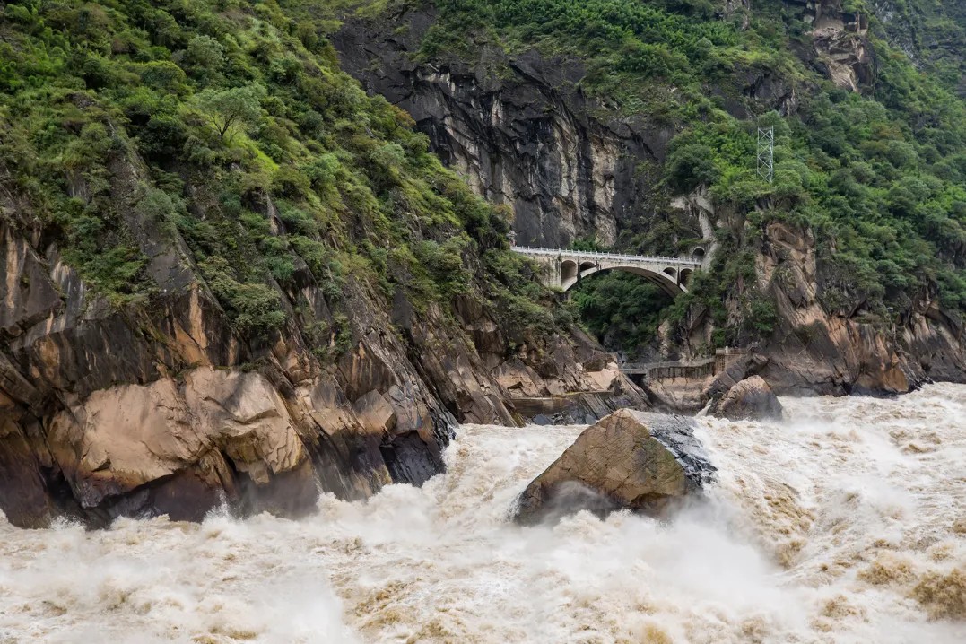 14:00 Arrive at Tiger Leaping Gorge. In the 100-meter canyon, there are many reefs, jagged and interlaced, the water is turbulent, the cool waves hit the shore, and countless snowy waves and smoke are rolled up. The river surface has a large drop. Between