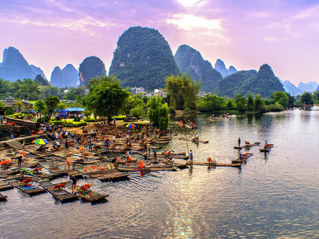 遇龍河竹筏：漂流途中每過一個堤壩，竹筏輕躍而下，水花微濺，平添幾分趣味。船工時常哼唱當地小調，更添悠然情調。這段靜謐而靈動的旅程，將成為您陽朔之旅中最難忘的記憶。