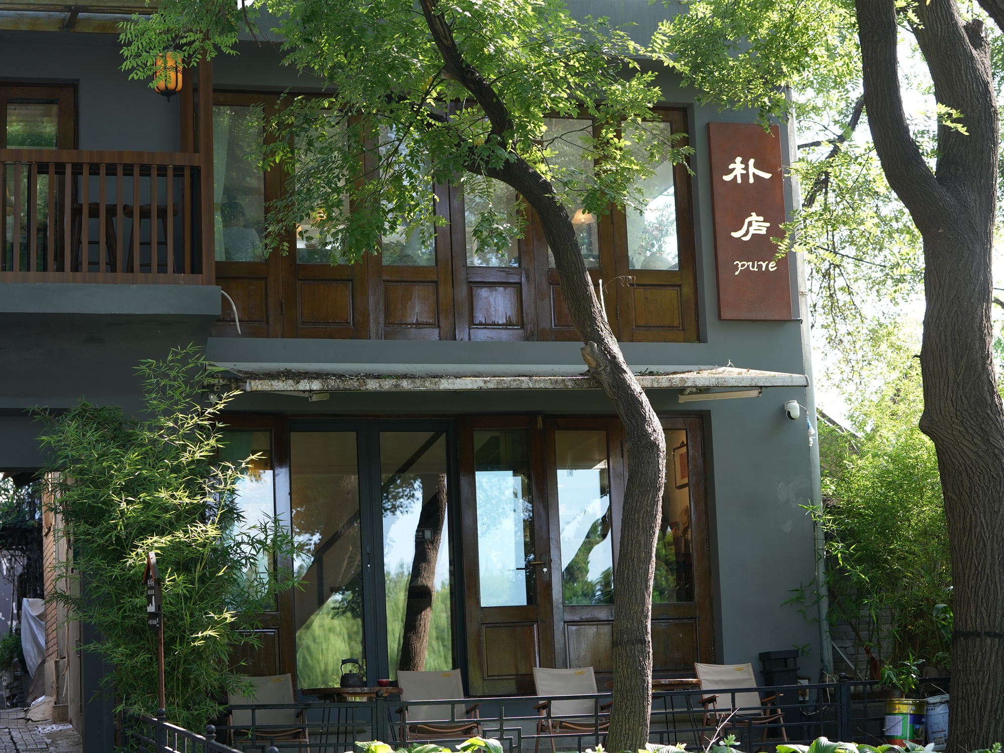 樸廬茶舍外觀，灰牆木窗，綠樹環繞，盡顯雅緻靜謐