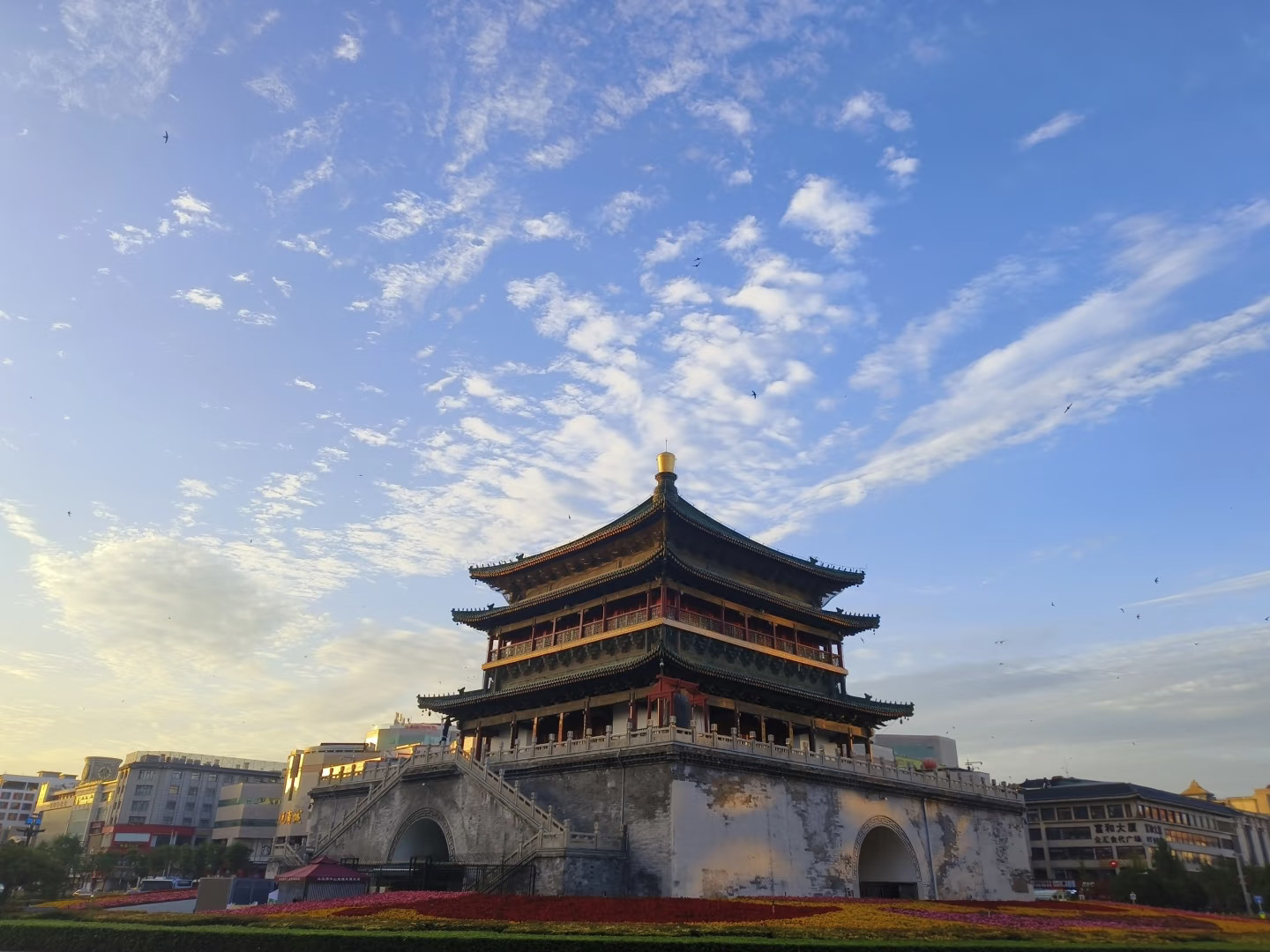 西安鐘樓：清晨流雲漫過古樓，陽光輕灑青瓦木廊，周邊現代樓宇環繞，一眼看懂千年古城的新舊碰撞