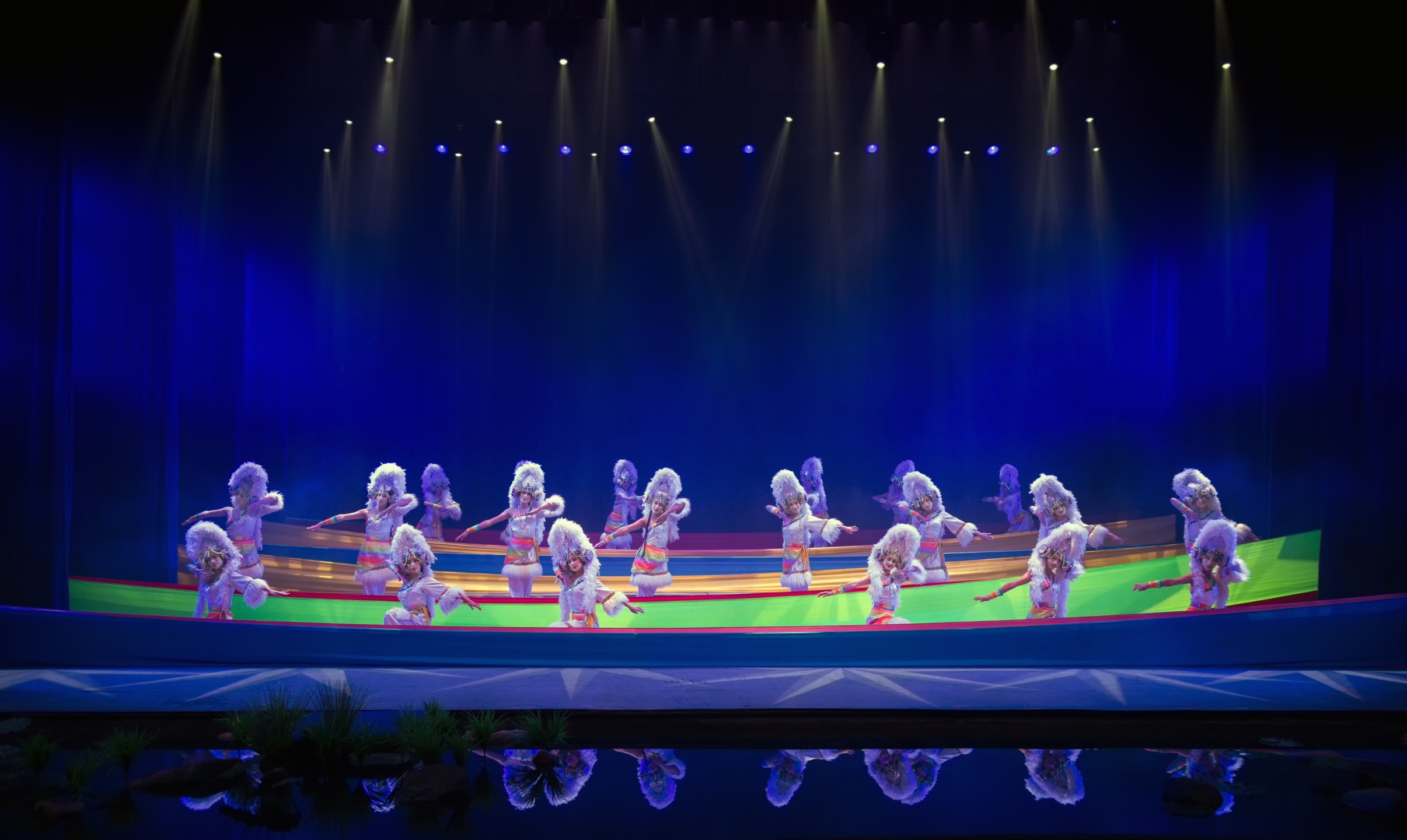 腳下的彩色發光地板與水面倒影相映成趣，彷彿化身雪域高原的精靈，演繹出納西族 “雪山之靈” 的靈動與聖潔