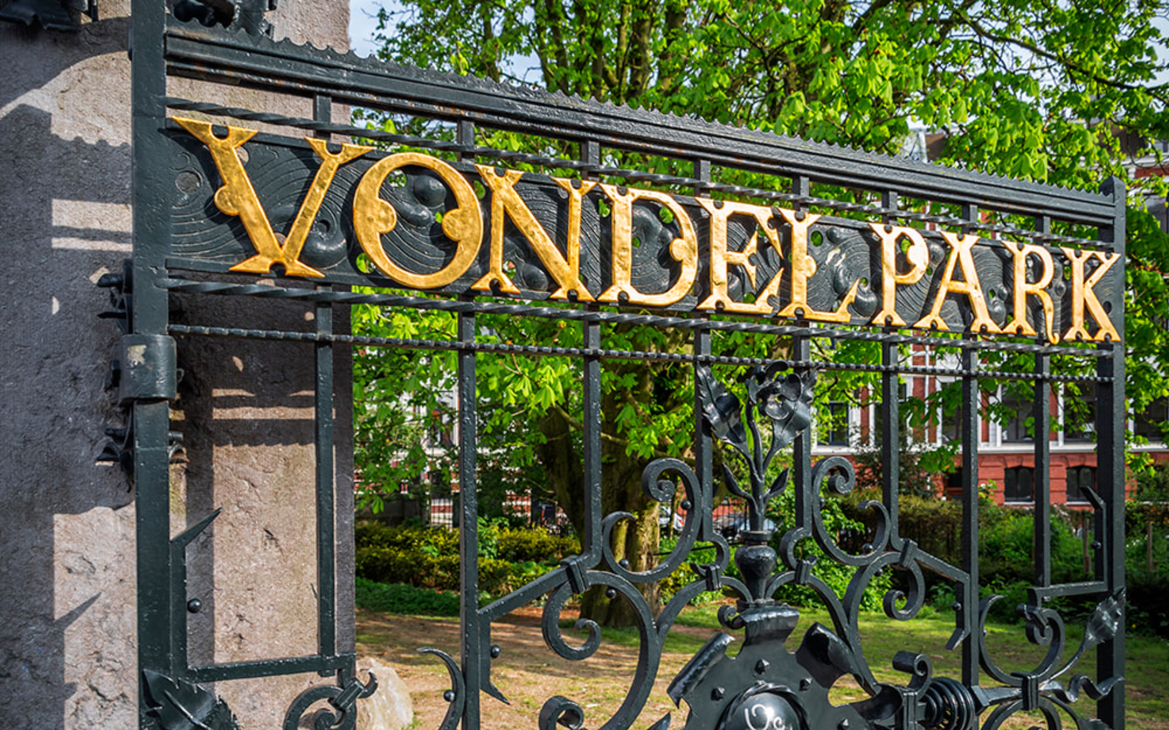 Locals and visitors relax amid green lawns, tranquil ponds, and blooming trees in Vondelpark
