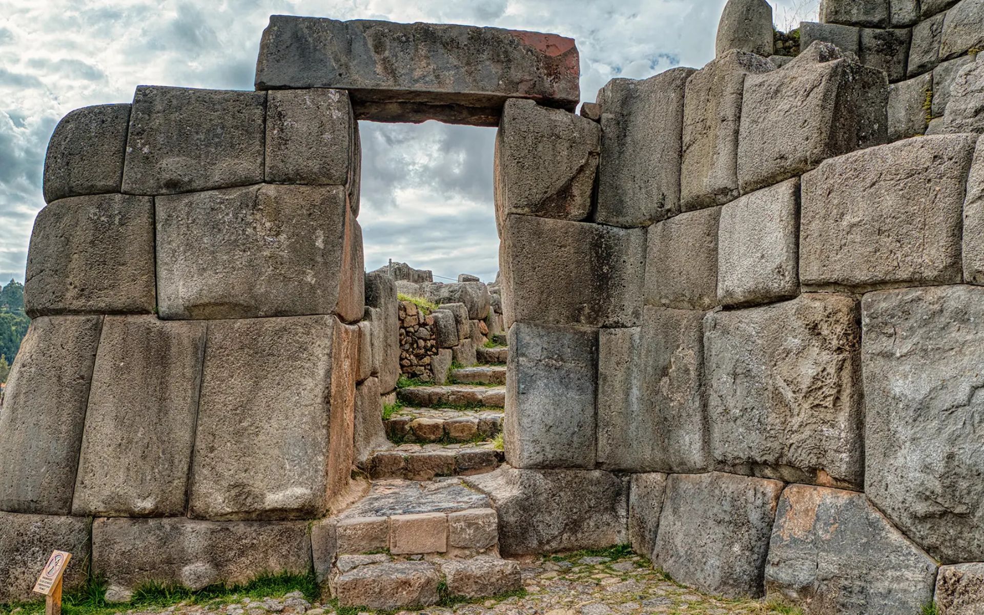 漫步穿越薩克塞瓦曼巨石堡壘 (Saqsaywaman) 巨大且精確雕刻的石門。 漫步穿越薩克塞瓦曼巨石堡壘 (Saqsaywaman) 巨大且精確雕刻的石門。