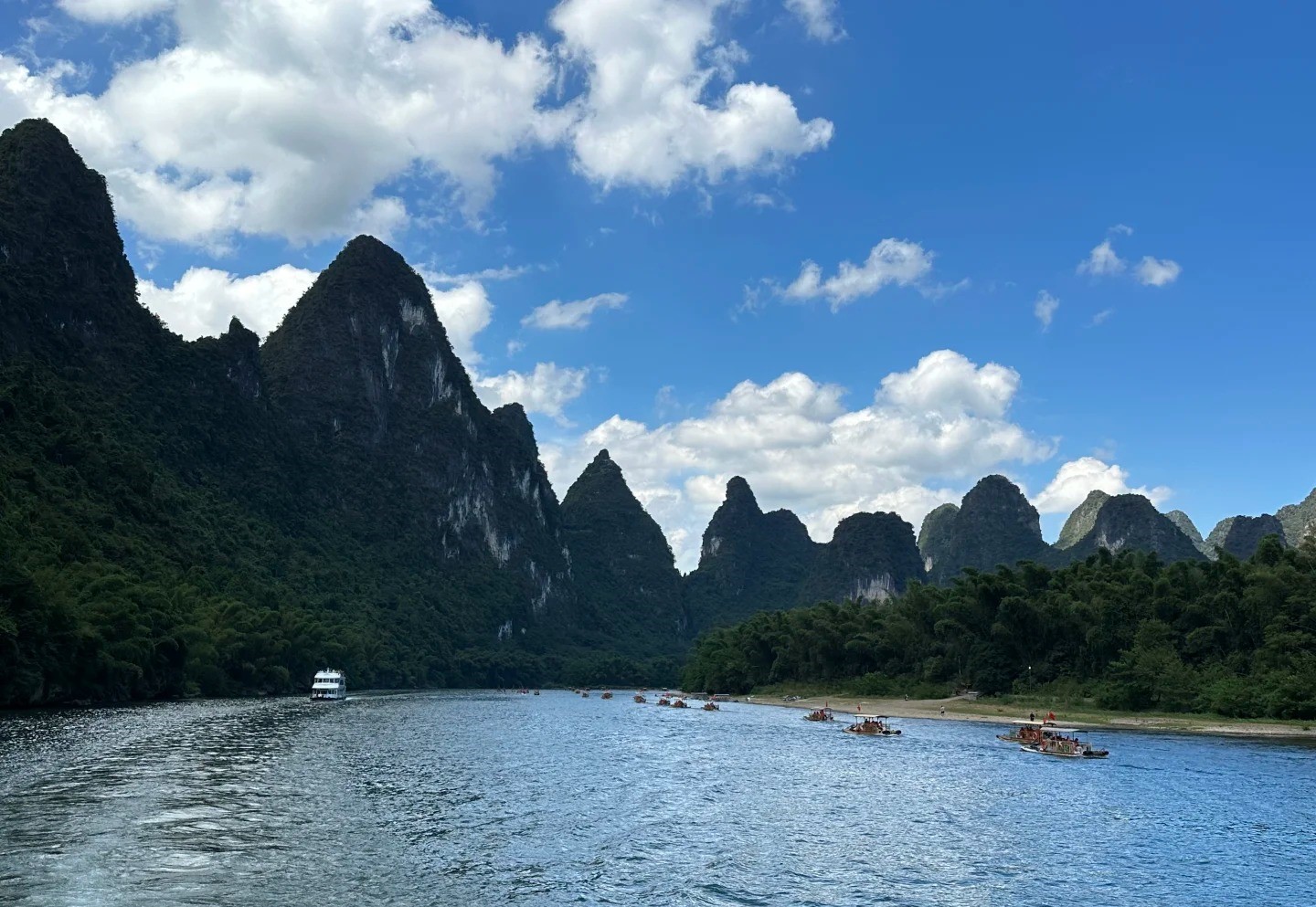 陽光穿透雲層灑在江面,青峰倒影清晰如畫,色彩鮮亮得像打翻了調色盤 陽光穿透雲層灑在江面,青峰倒影清晰如畫,色彩鮮亮得像打翻了調色盤