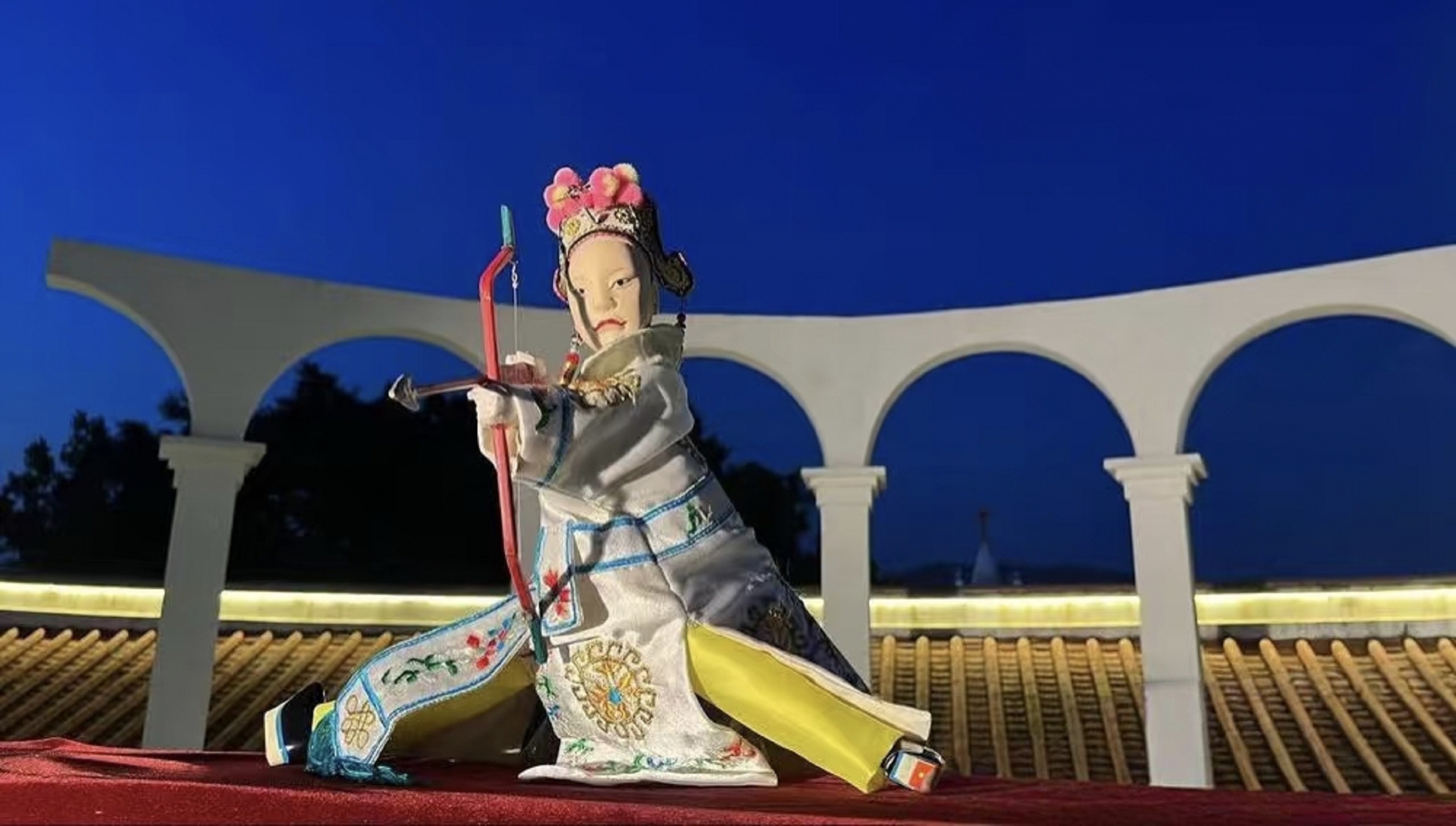 晚風掠過紅絨檯布，木偶的袖擺輕揚，像把古戲裡的俠氣，揉進了泉州老城的暮色裡