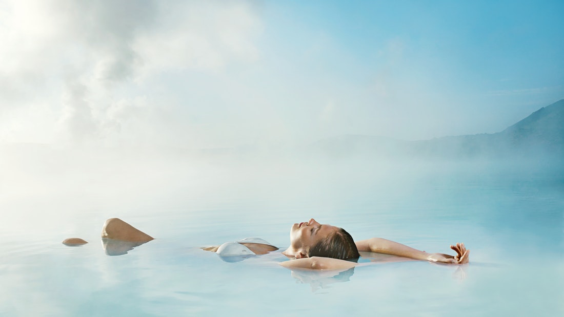 woman floating in water of blue lagoon