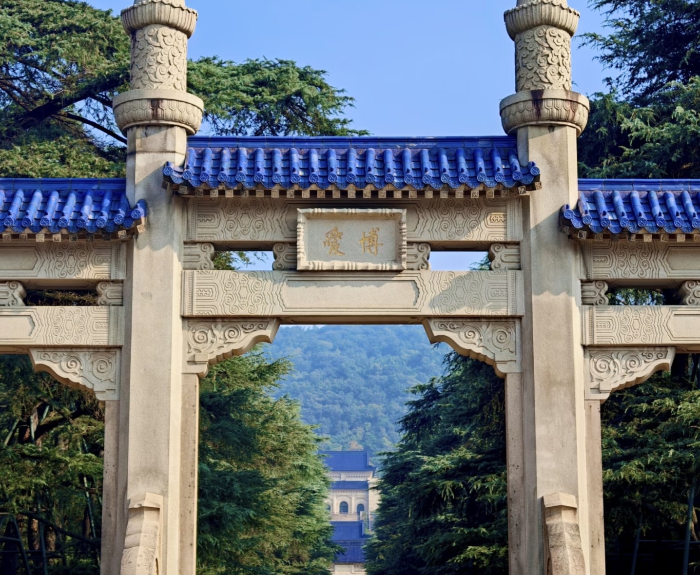 牌坊後是濃廕庇日的蒼松翠柏,遠處紫金山巒與中山陵主體建築在晴空下若隱若現,莊嚴肅穆的氛圍撲面而來 牌坊後是濃廕庇日的蒼松翠柏,遠處紫金山巒與中山陵主體建築在晴空下若隱若現,莊嚴肅穆的氛圍撲面而來