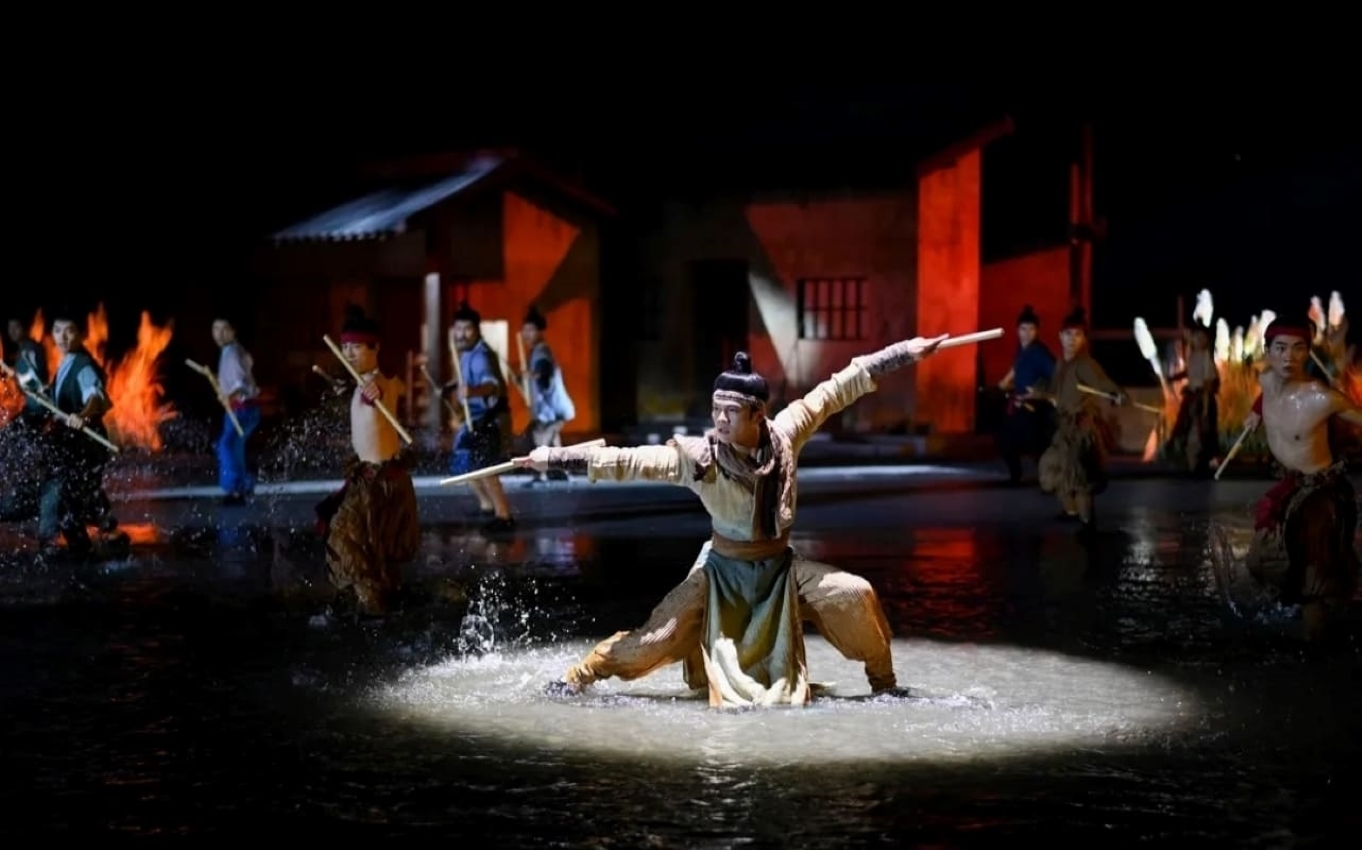舞者在水中持槌,身姿矯健、動作剛猛。背景火光與古建烘托氛圍,還原潮汕傳統英歌舞的豪邁氣勢,借水花飛濺展現民俗活動的熱血與生命力 舞者在水中持槌,身姿矯健、動作剛猛。背景火光與古建烘托氛圍,還原潮汕傳統英歌舞的豪邁氣勢,借水花飛濺展現民俗活動的熱血與生命力