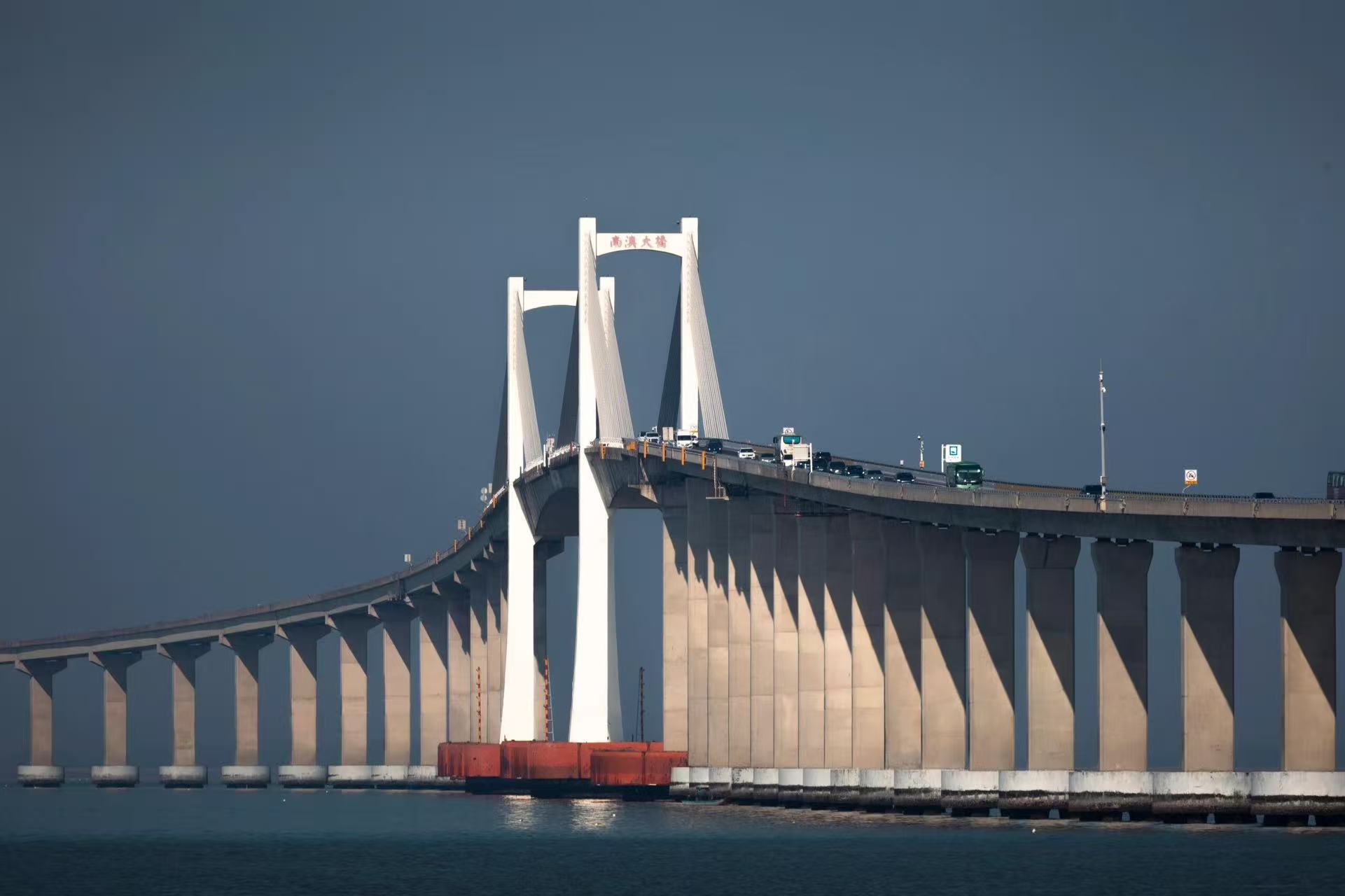 南澳大橋橫亙海面,白色橋塔挺拔矗立,灰褐色橋墩整齊排開。冷調的天地間,橋面車流穿梭,紅底防撞設施點綴其間,盡顯工程的宏偉與山海間的沉靜。 南澳大橋橫亙海面,白色橋塔挺拔矗立,灰褐色橋墩整齊排開。冷調的天地間,橋面車流穿梭,紅底防撞設施點綴其間,盡顯工程的宏偉與山海間的沉靜。