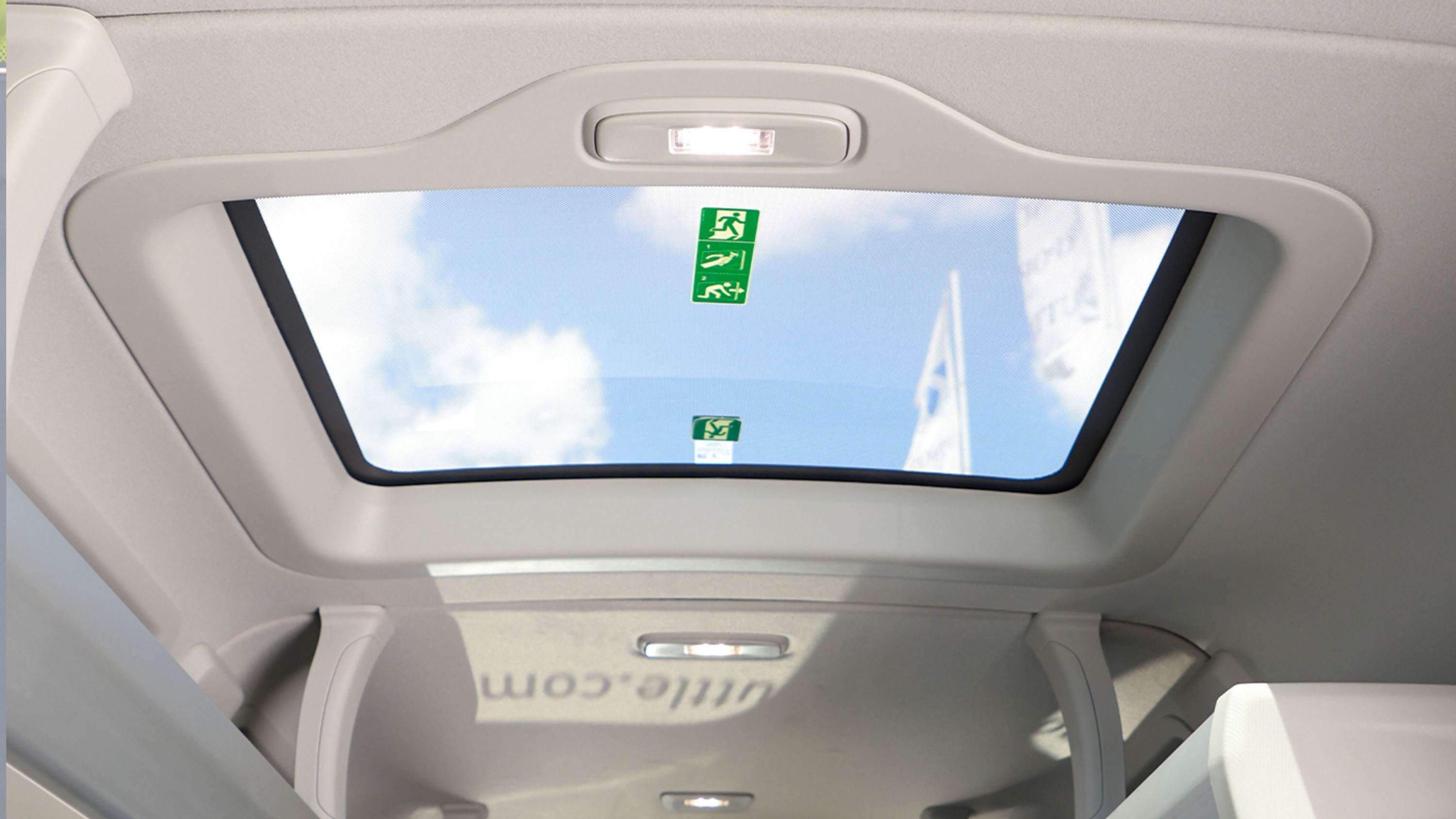 Bright sunroof overhead letting natural light fill the modern, air-conditioned shuttle interior