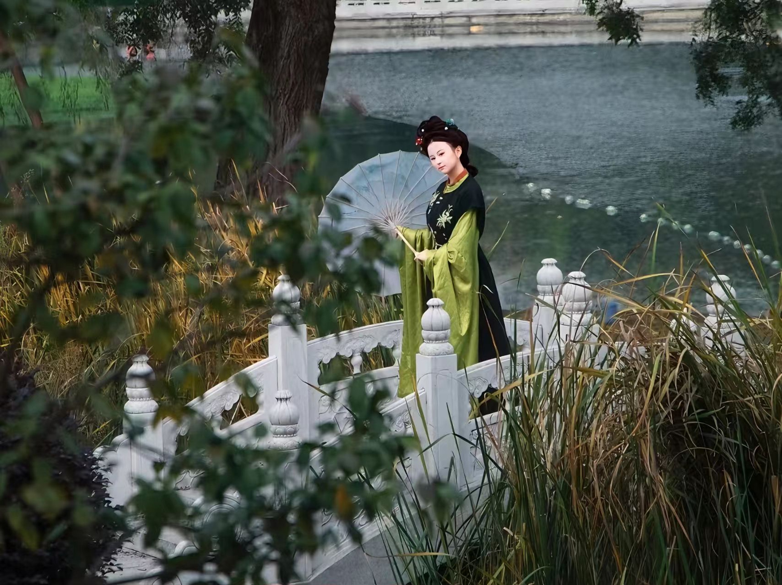 墨綠漢服配淺綠廣袖,少女持傘立於石橋,草木掩映間,盡顯古典仕女的沉靜與溫婉 墨綠漢服配淺綠廣袖,少女持傘立於石橋,草木掩映間,盡顯古典仕女的沉靜與溫婉