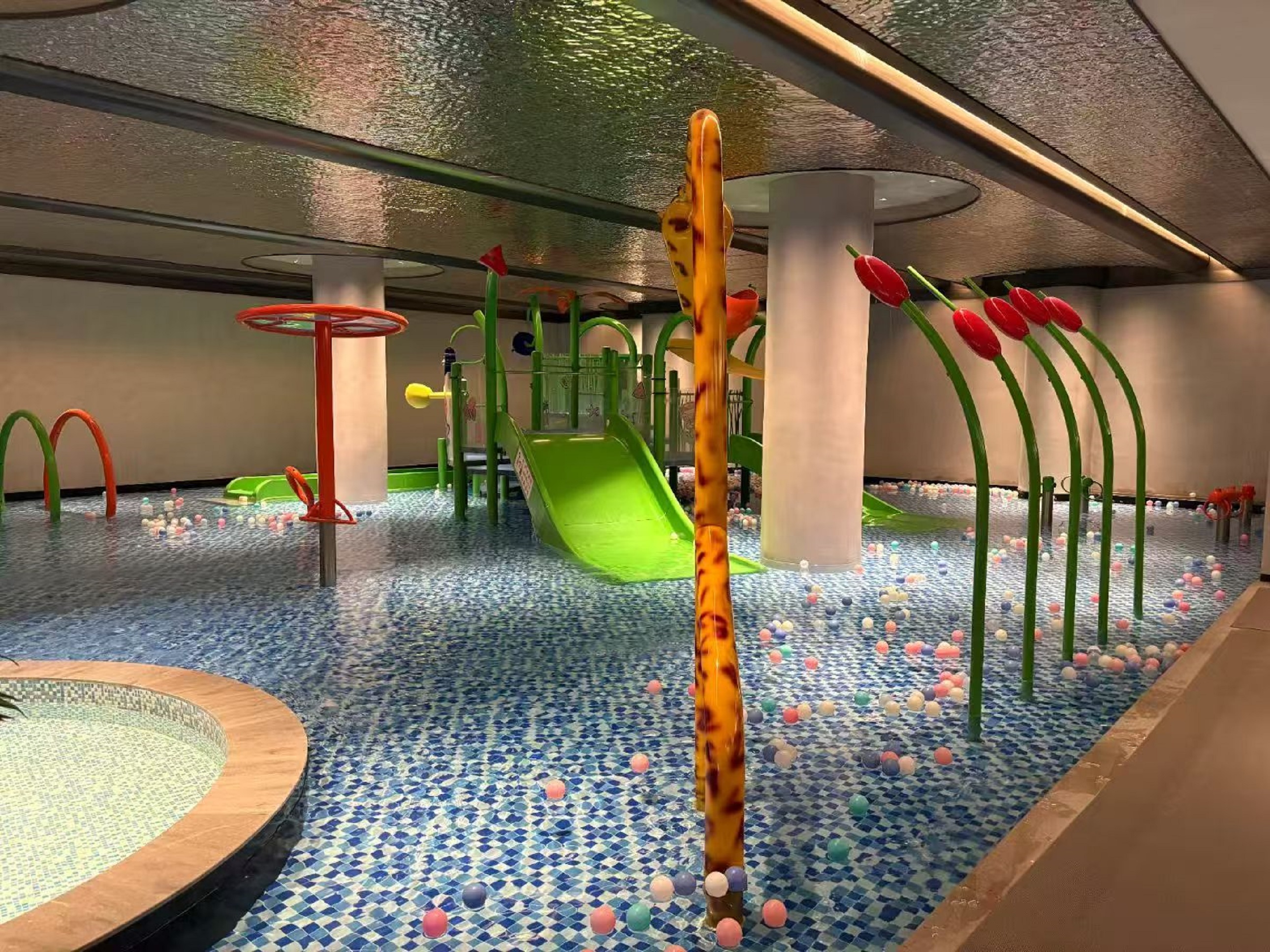 室內兒童水上游樂區充滿童趣,綠色的滑梯、彩色的噴水裝置,孩子們可以在這裡盡情享受水上游樂的樂趣 室內兒童水上游樂區充滿童趣,綠色的滑梯、彩色的噴水裝置,孩子們可以在這裡盡情享受水上游樂的樂趣