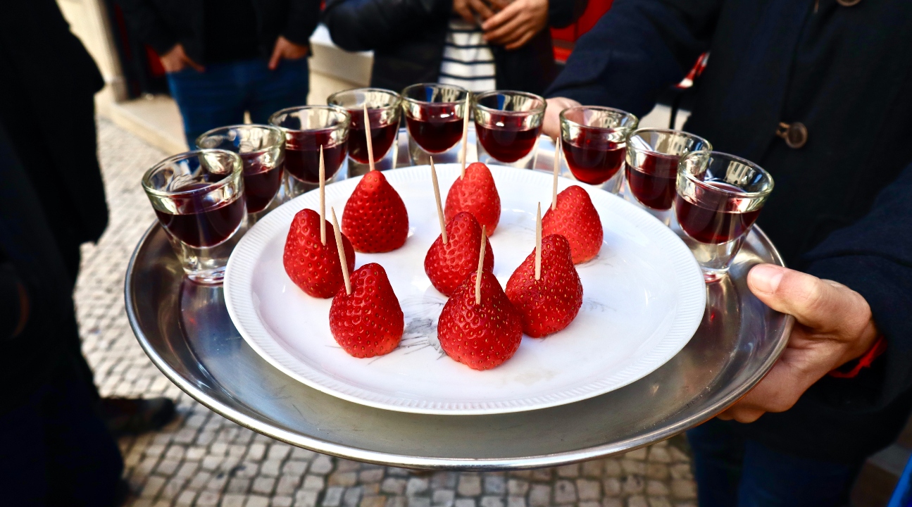 shot glasses with wine served with strawberries on sticks