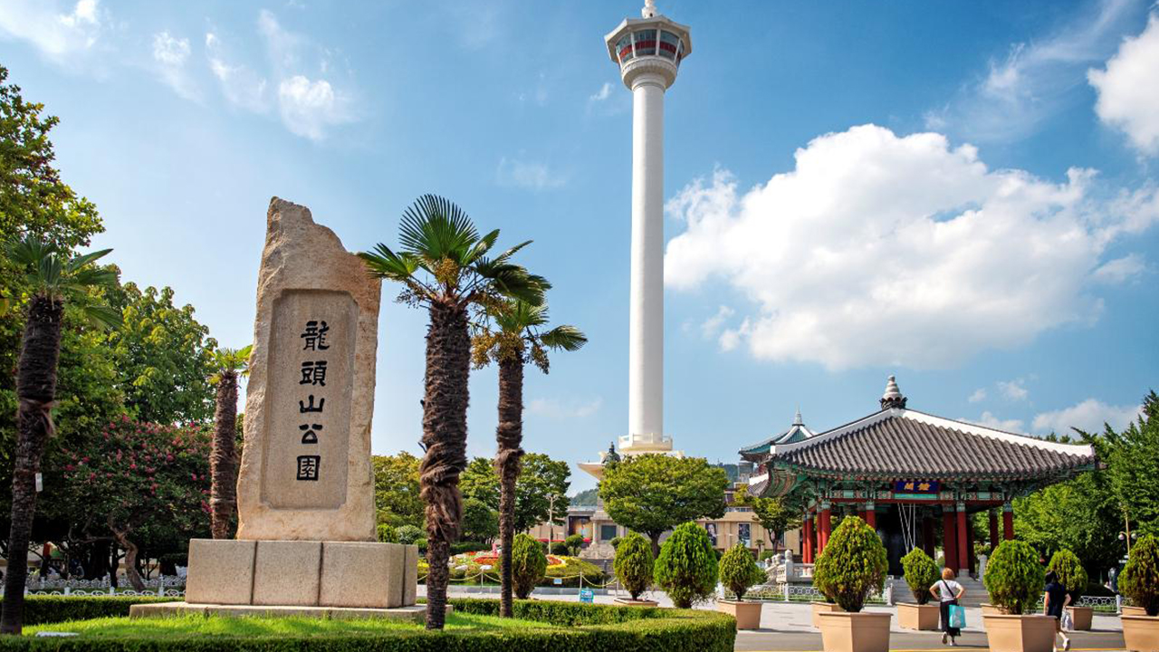 漫步於龍頭山公園，盡享釜山熱鬧港口與城市天際線的壯麗全景。