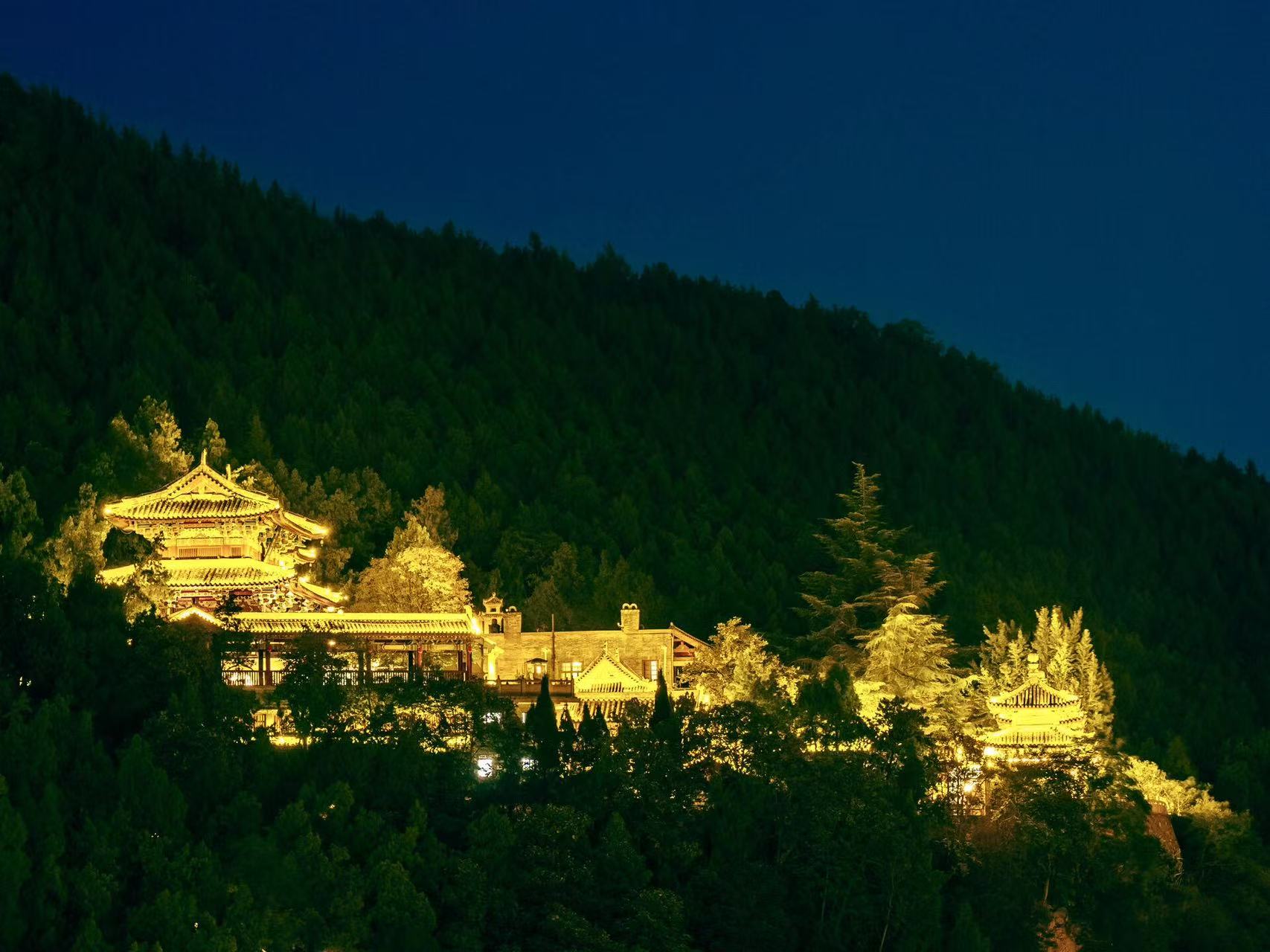 深山古寺的夜景:依山而建的中式樓閣被暖光勾勒,飛簷翹角在墨綠山林間格外醒目,與深邃的夜空形成強烈對比,盡顯禪院清幽與古樸莊重 深山古寺的夜景:依山而建的中式樓閣被暖光勾勒,飛簷翹角在墨綠山林間格外醒目,與深邃的夜空形成強烈對比,盡顯禪院清幽與古樸莊重