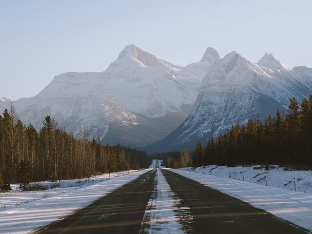 The vast Columbia Icefield Parkway stretching into the horizon, framed by towering cliffs