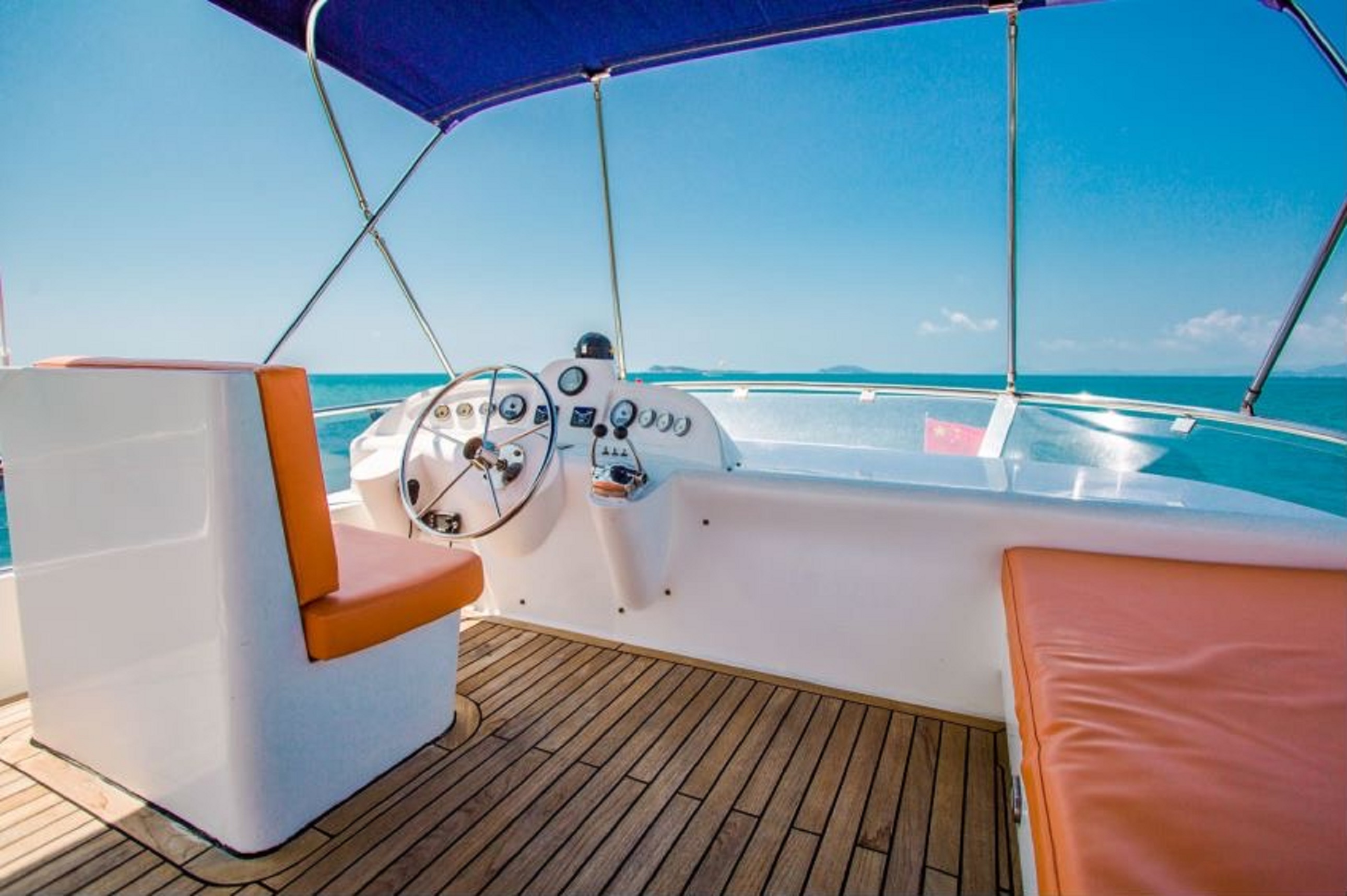 The sunlight unreservedly covers the driving deck. The white console is paired with orange leather seats, and the wooden floor reflects a warm luster in the light and shadow.
