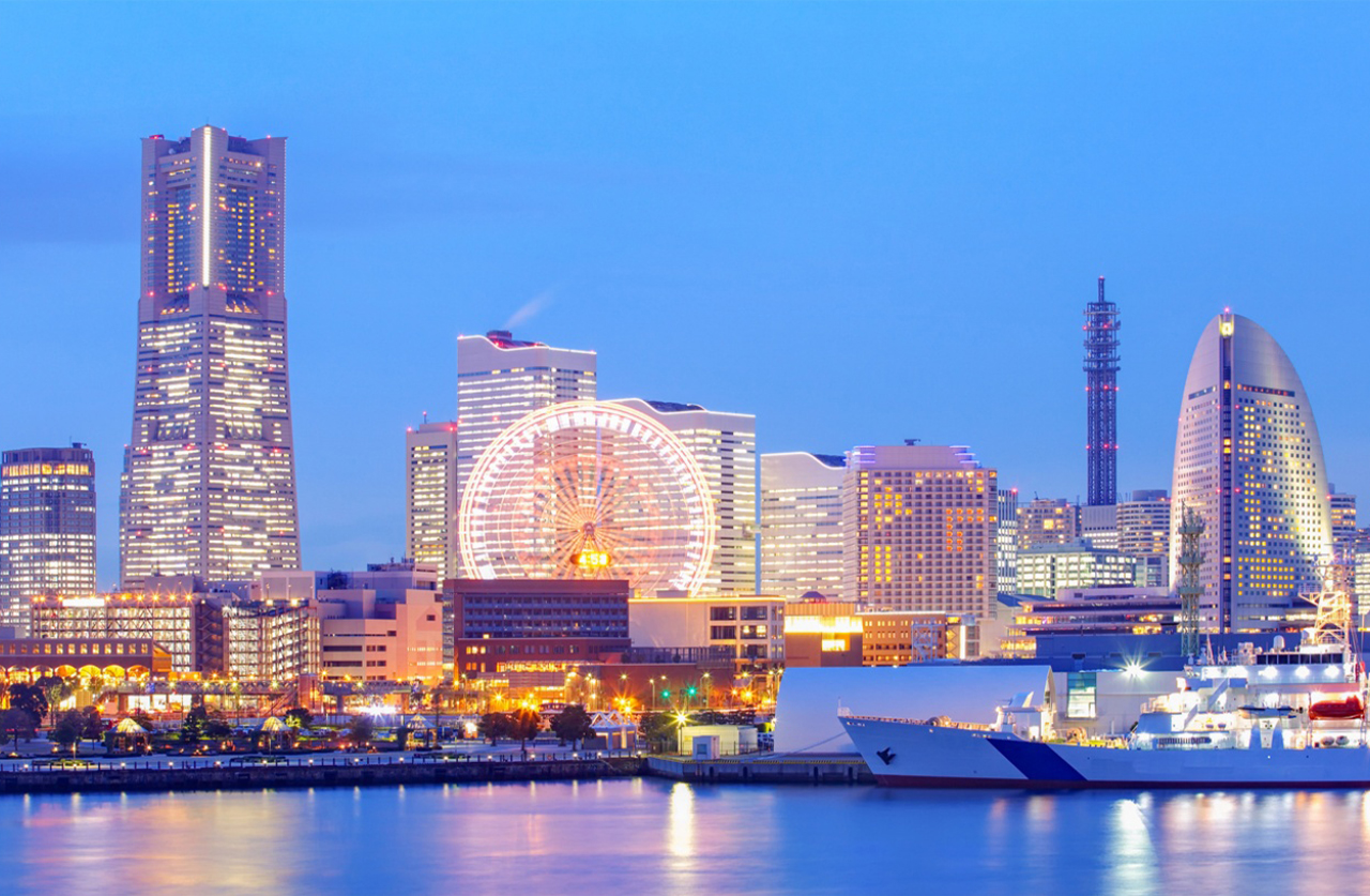 港口遊船緩緩駛過，燈光倒影與城市夜景相互輝映。