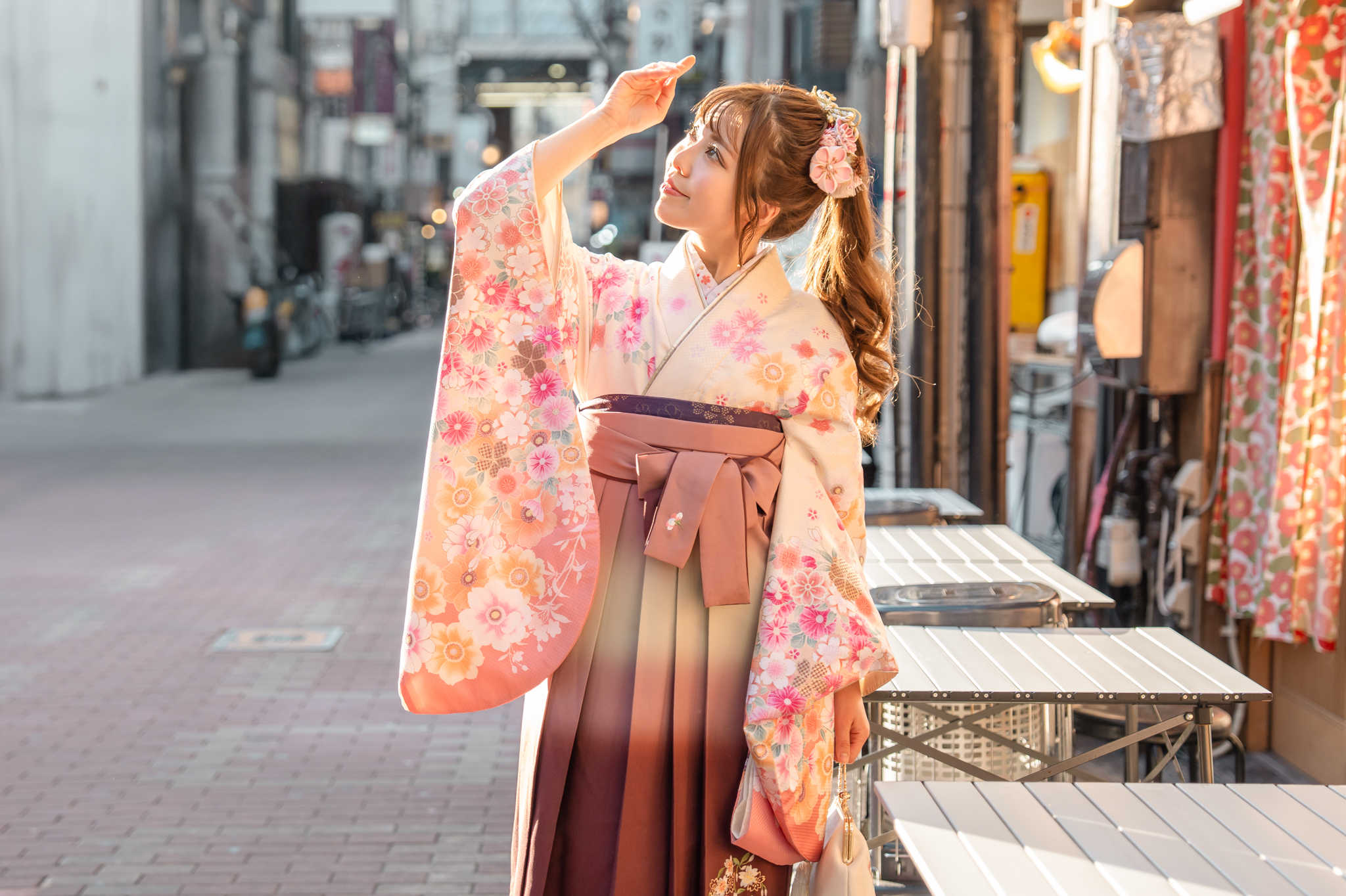 淡粉色和花朵圖案的和服,散發著柔和的氛圍,搭配色調沉穩的袴,兼具春天的可愛和優雅,即使在街上也顯得輕盈華麗。 淡粉色和花朵圖案的和服,散發著柔和的氛圍,搭配色調沉穩的袴,兼具春天的可愛和優雅,即使在街上也顯得輕盈華麗。