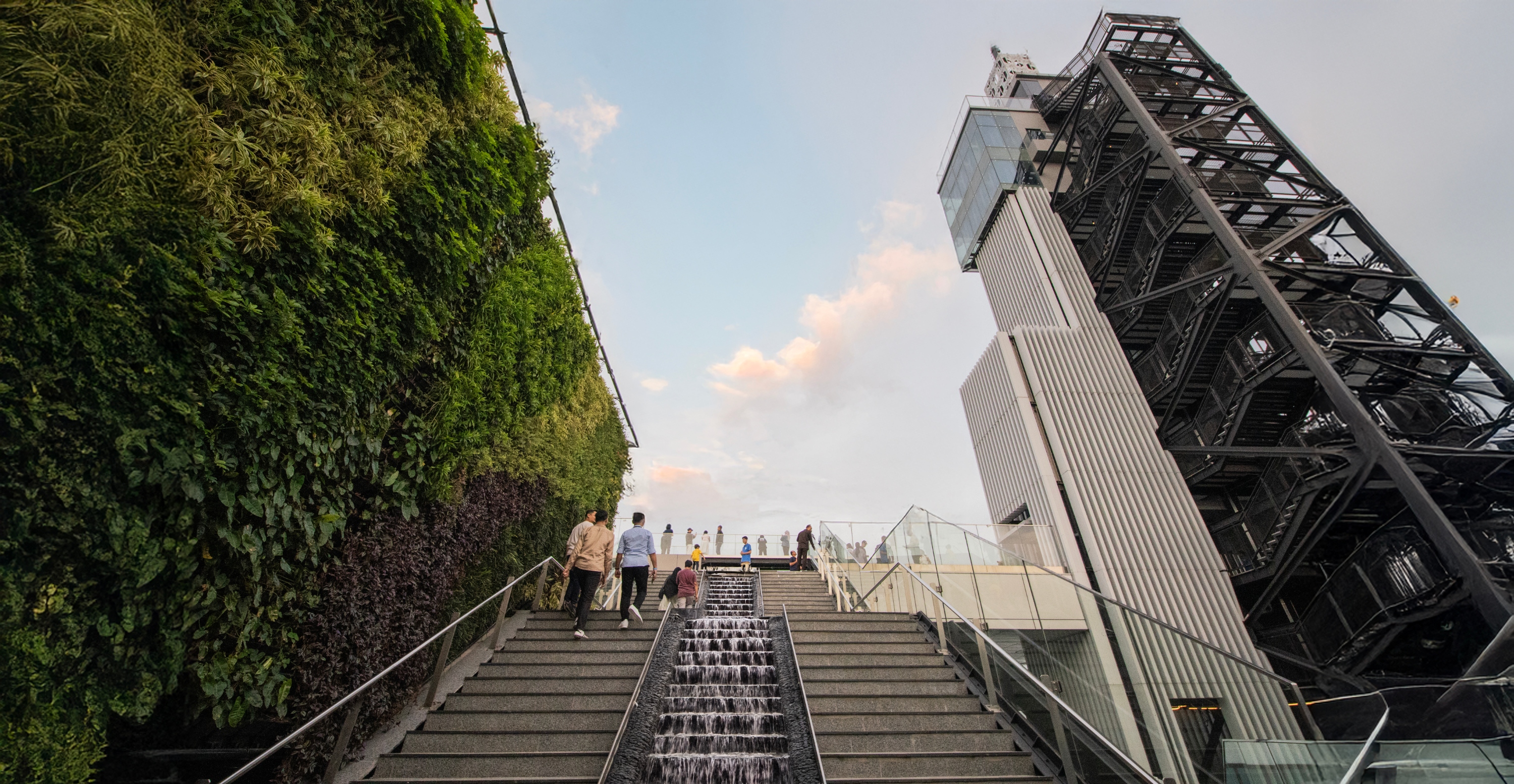通往天空的階梯，周圍環繞著綠色牆壁和城市景觀