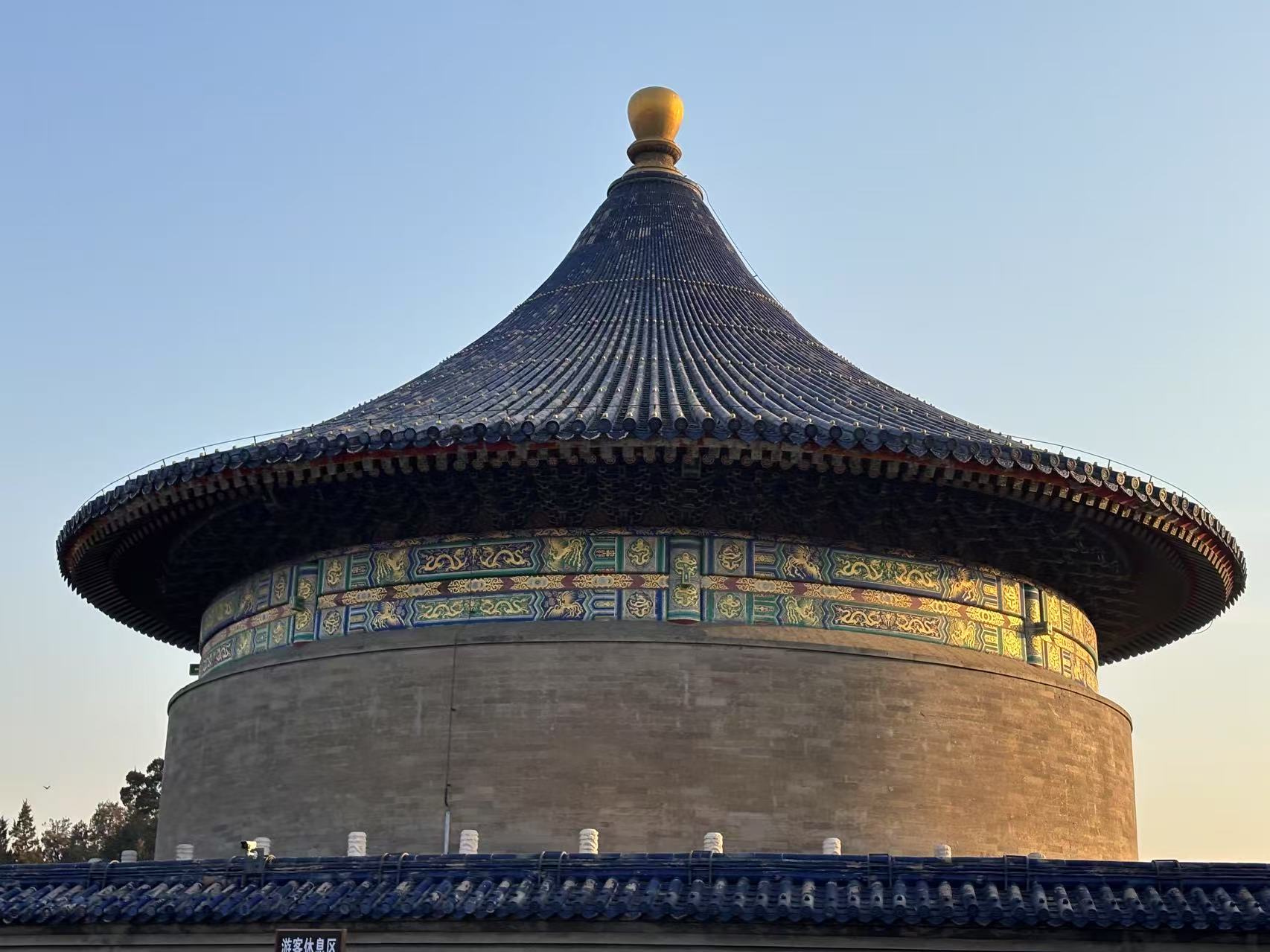 繼續我們的行程，跟隨導遊一起來到天壇公園的核心建築——祈年殿。這座三重簷圓形大殿以其獨特的造型和精美的裝飾聞名於世，是明清兩代皇帝祭天祈谷的聖地。殿內的28根金絲楠木大柱分別象徵著四季、十二月和十二時辰，寓意天地萬物的和諧與循環。跟隨導遊詳細瞭解古代祭祀儀式的流程與文化內涵，比如皇帝如何通過祭天表達對自然的敬畏與感恩。站在殿前，仰望其恢宏的穹頂與精美的彩繪，彷彿能感受到古人“敬天法祖”的莊重與虔誠。祈年殿不僅是建築藝術的傑作，更是中華文化中“天人合一”思想的完美體現。