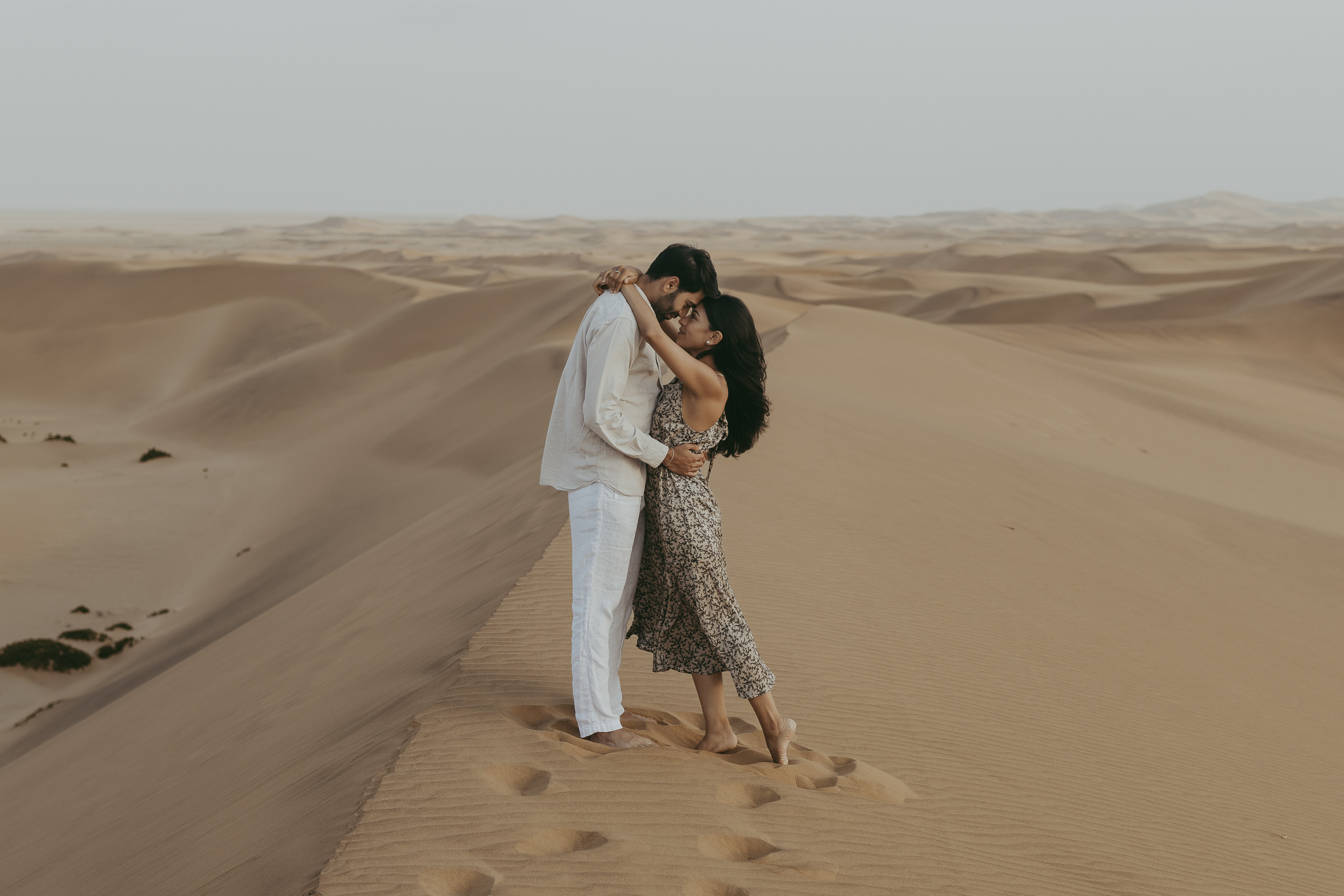 Couple on top of the dune with the Namib desert in the background