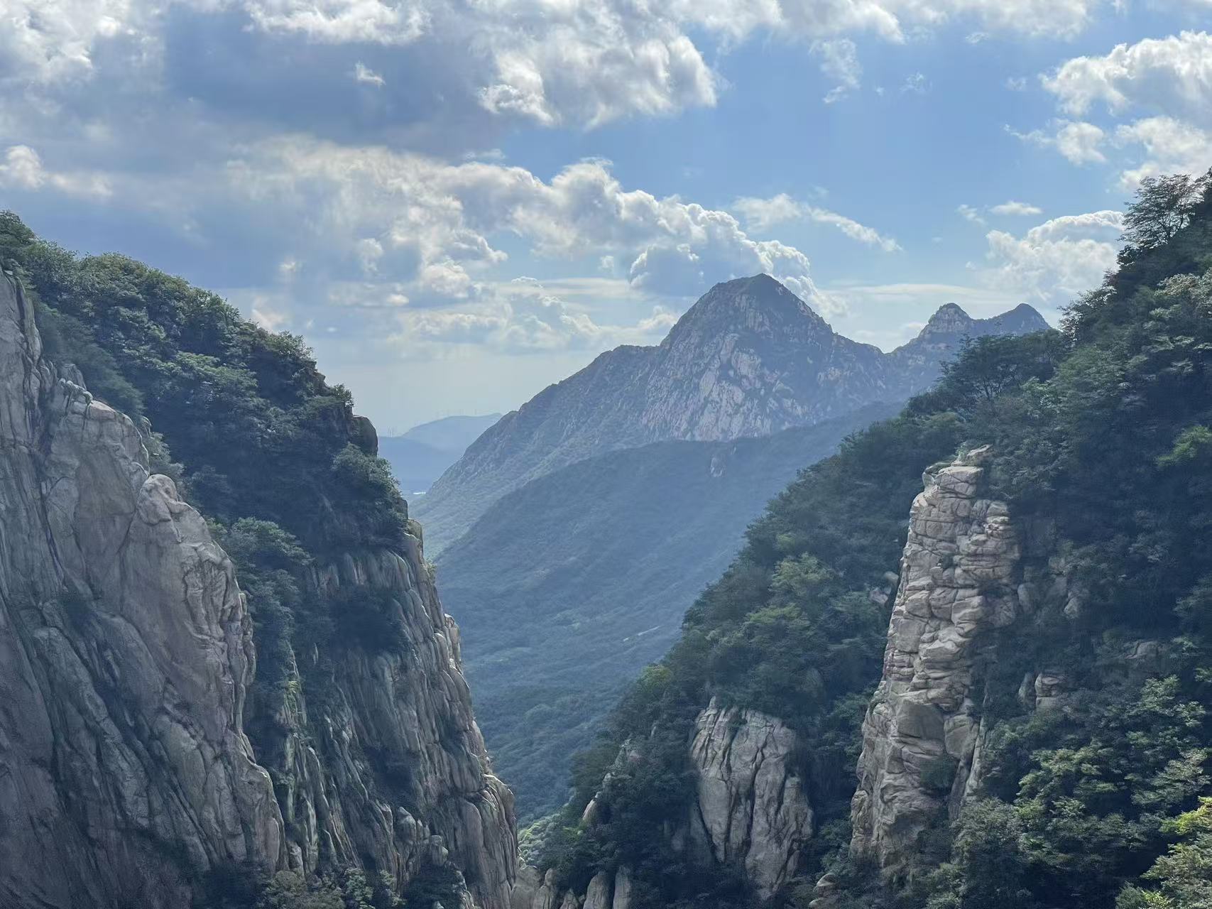 嵩山峽谷全景:兩側陡峭巖壁被茂密植被覆蓋,遠處峰巒巍峨,藍天白雲映襯下,峽谷幽深壯闊,展現了中嶽嵩山的雄渾自然風貌 嵩山峽谷全景:兩側陡峭巖壁被茂密植被覆蓋,遠處峰巒巍峨,藍天白雲映襯下,峽谷幽深壯闊,展現了中嶽嵩山的雄渾自然風貌