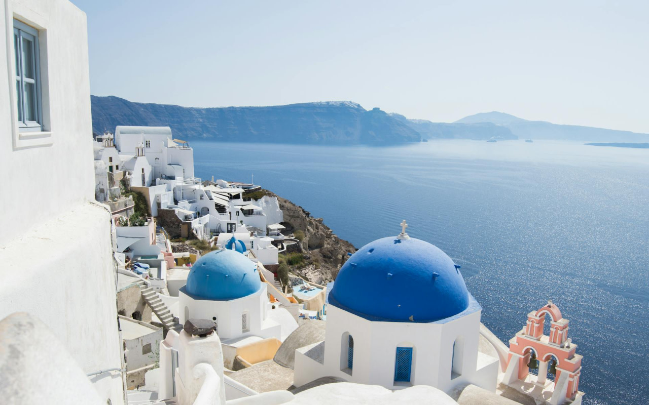 體驗伊亞（Oia）標誌性的藍頂教堂、白色村莊和一望無際的火山口美景。