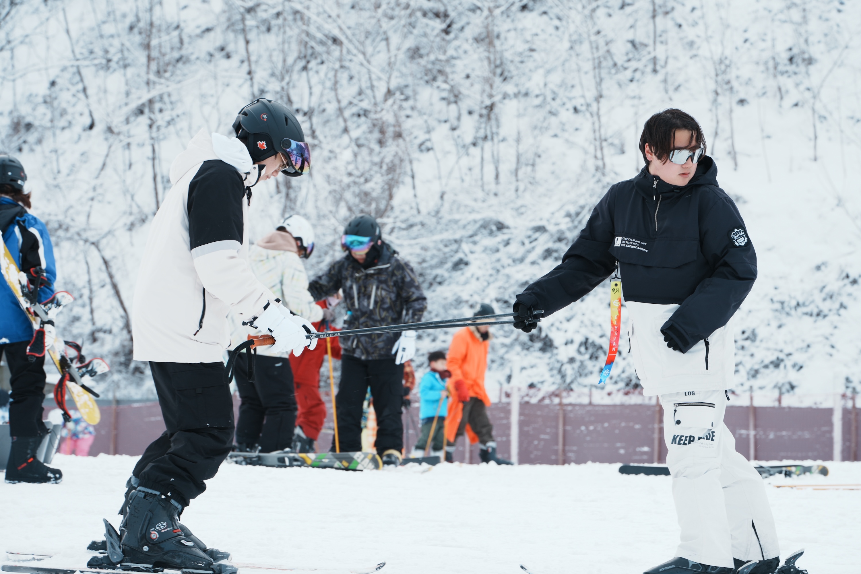 教練在雪地上指導初學單板滑雪客練習平衡與基本站姿。 教練在雪地上指導初學單板滑雪客練習平衡與基本站姿。
