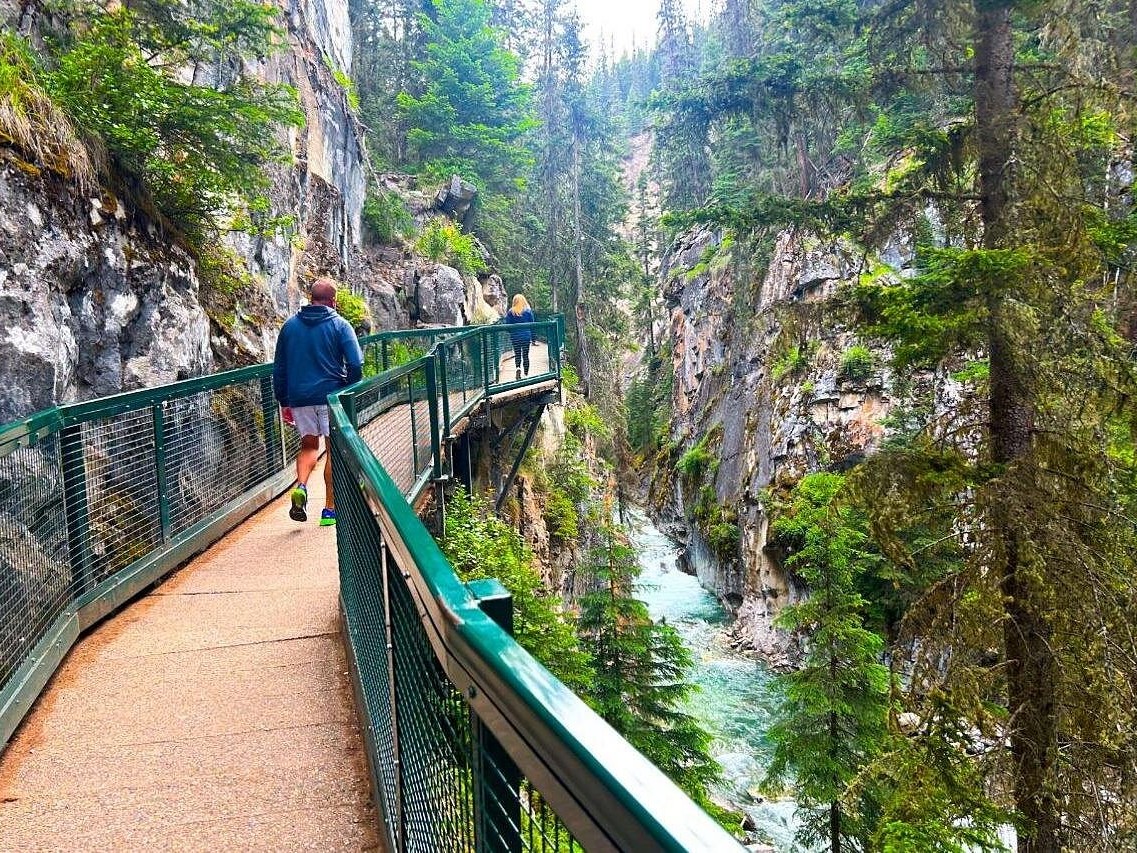 Gentle cascades of Bow Falls framed by lush evergreen forested surroundings