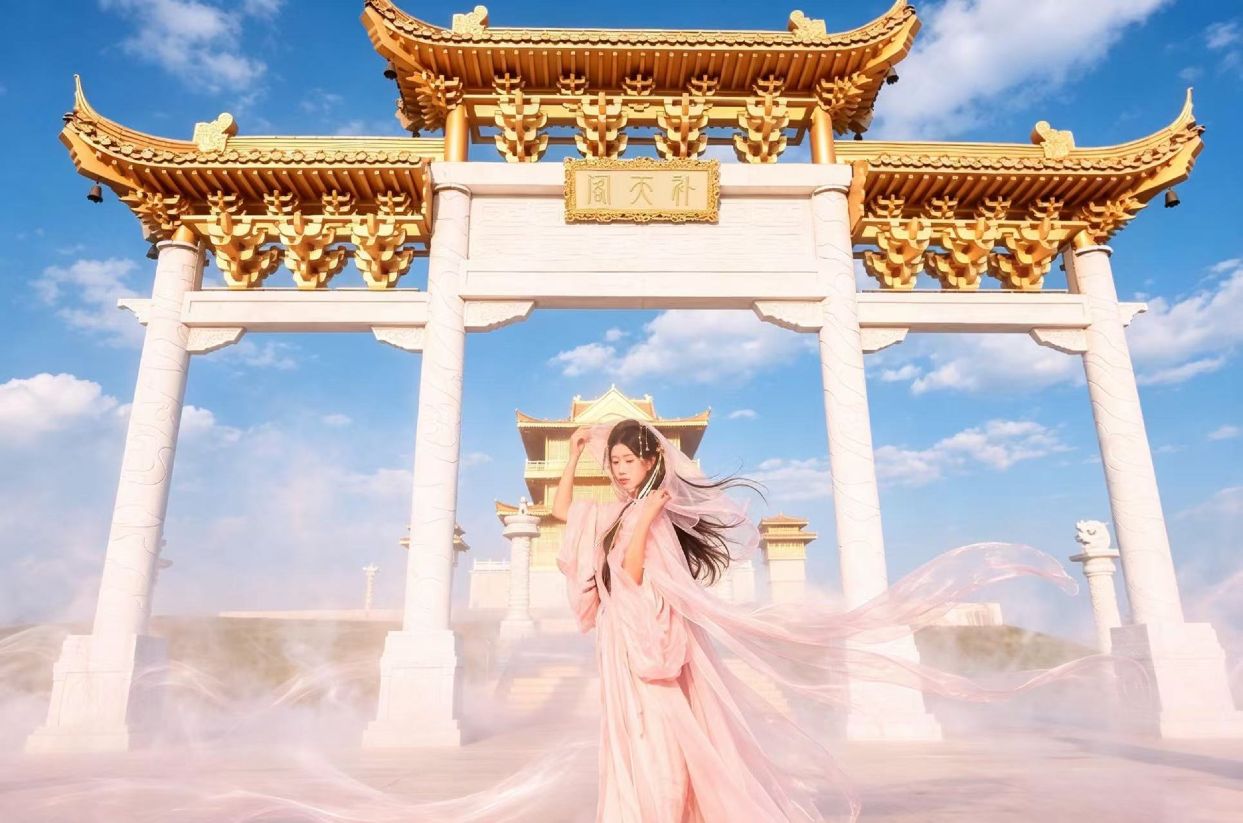 粉裙神女立於補天閣牌坊，雲霧繚繞，仙氣飄飄，古風氛圍感拉滿