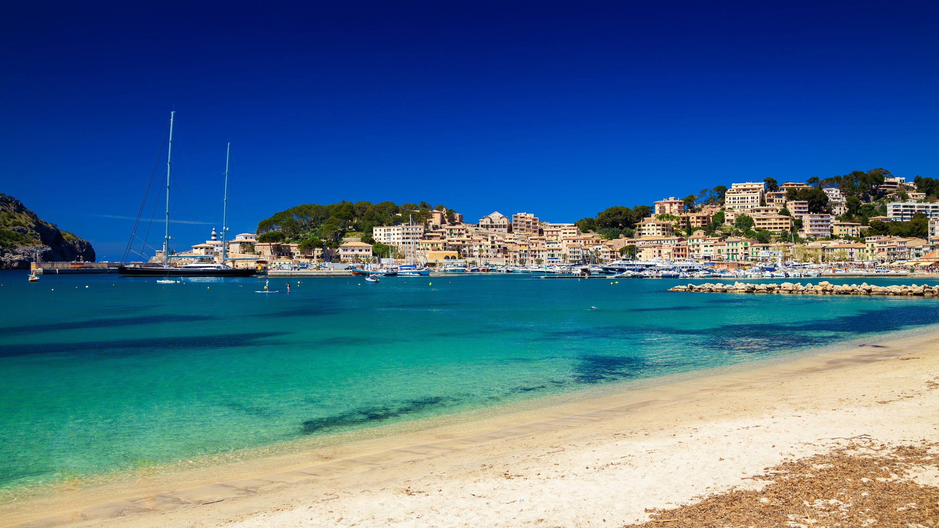 The calm waters of the Port of Soller, reflecting boats, and the surrounding hills