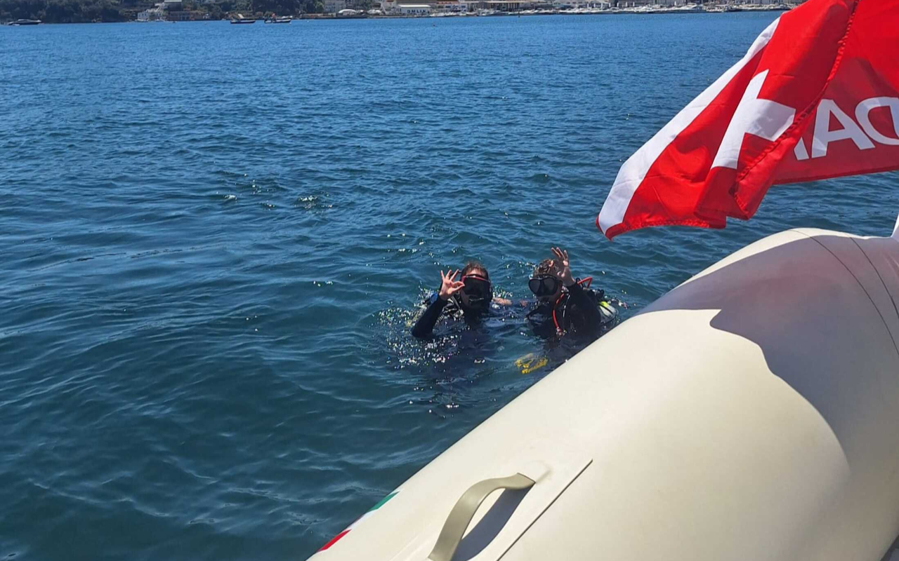 Diving into clear blue waters with incredible coastal scenery all around