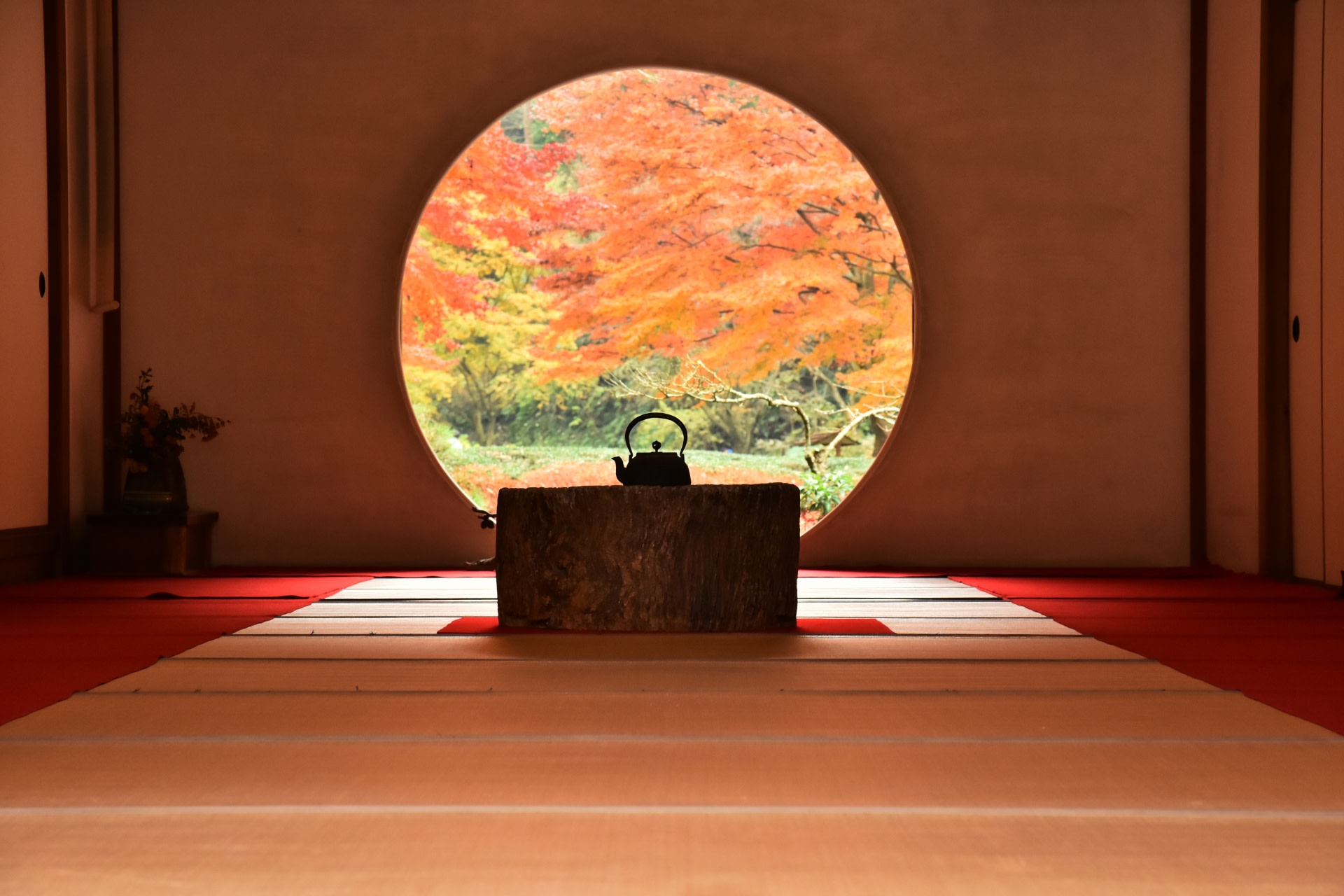 透過傳統的圓窗欣賞美麗的秋景，盡顯日本的寧靜之美。