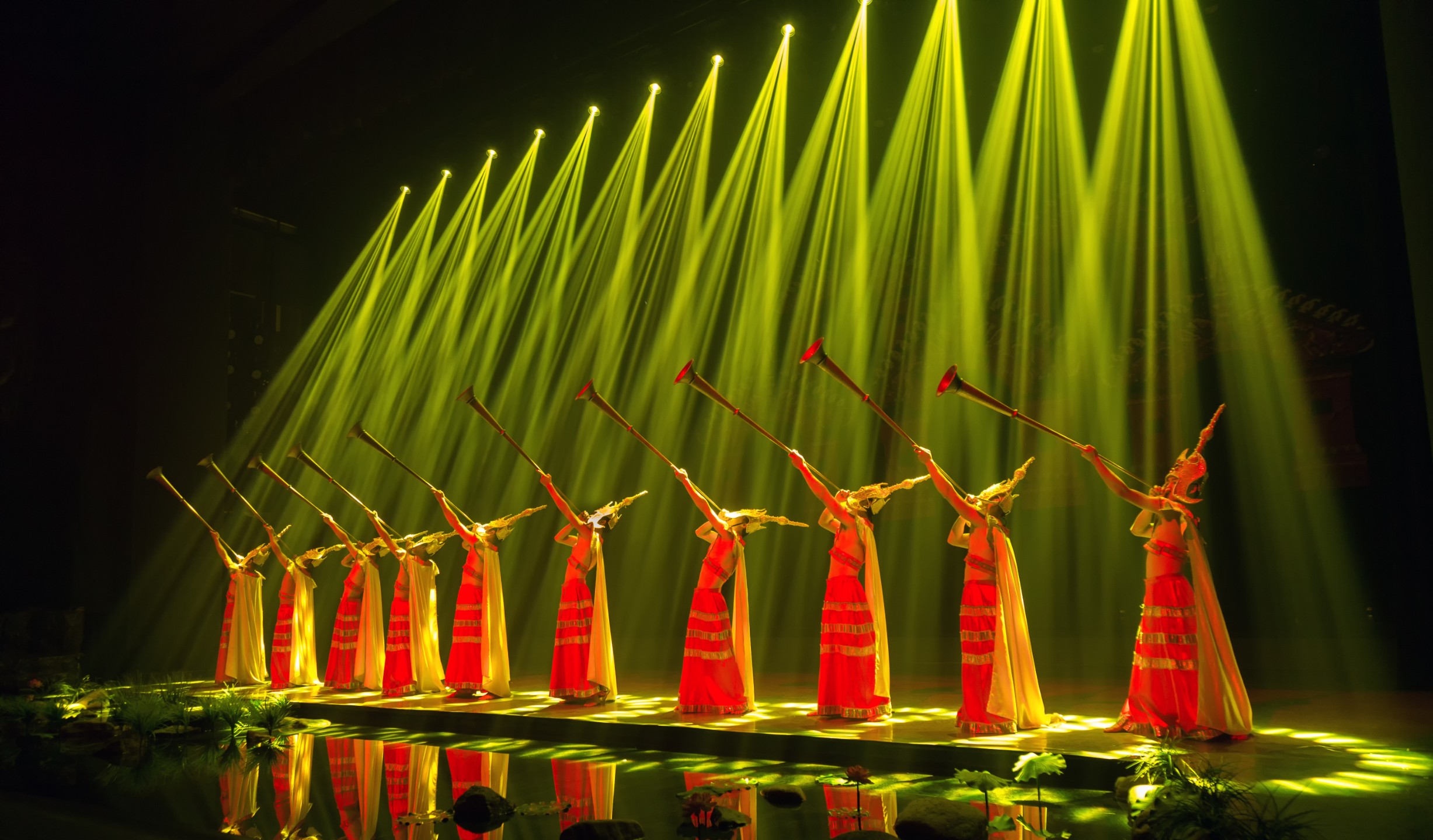 整齊的陣型與金色光柱呼應，營造出莊嚴又充滿力量感的壯族銅鼓樂舞氛圍