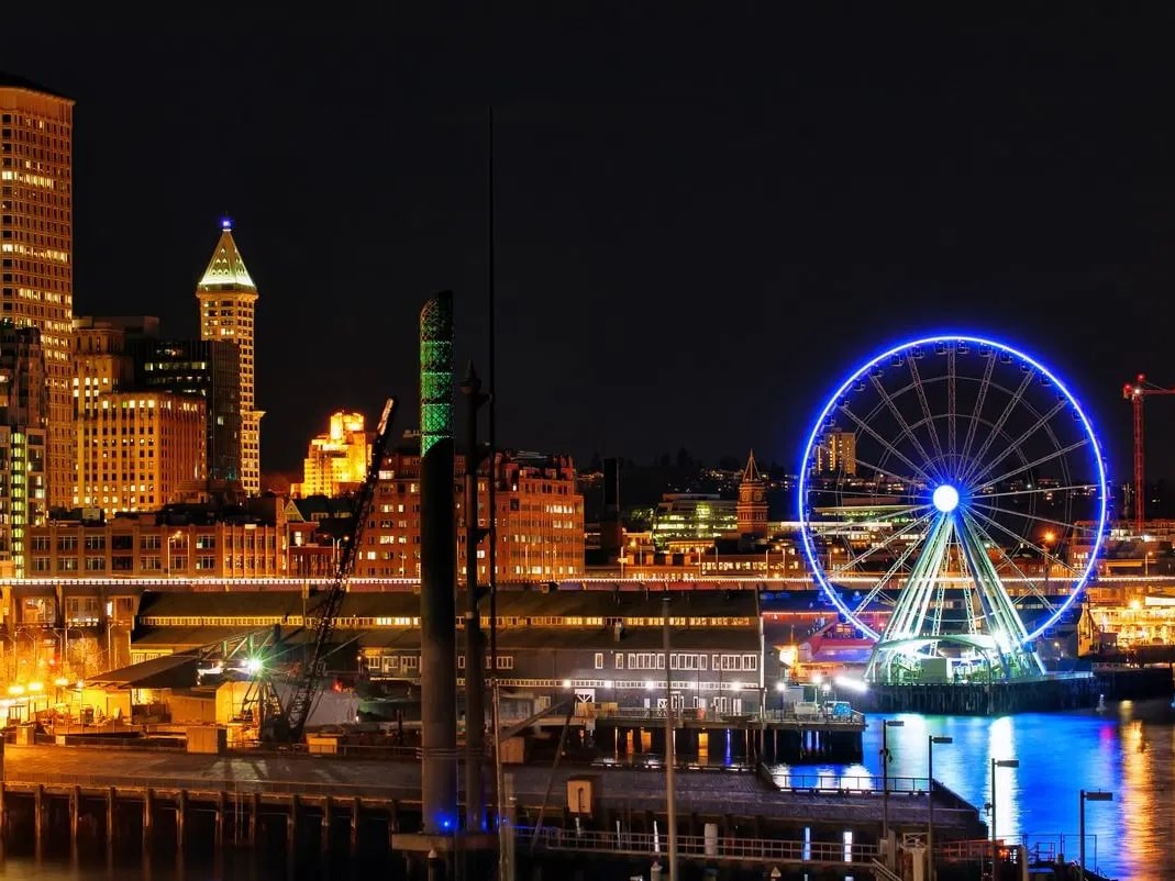 在迷人的夜間之旅中，欣賞西雅圖（Seattle）海濱的夜景、摩天輪和天際線