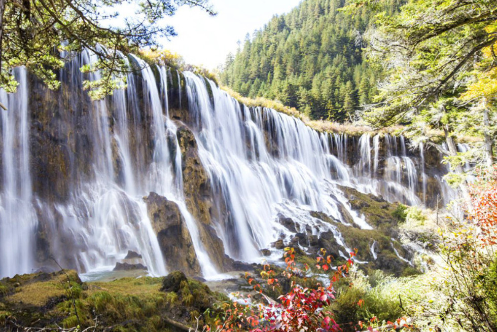 諾日朗瀑布：是迄今為止在我國發現的最寬的鈣華瀑布。“諾日朗”藏語中意指男神，也有偉岸高大的意思。滔滔水流自諾日朗群海而來，從瀑頂樹叢中越堤而下，如銀河飛瀉，水勢浩大，聲震山谷。
