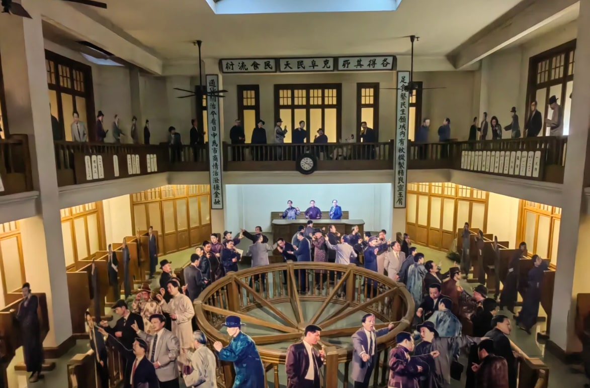 陳列館復刻老上海繁華金融場景，雙層空間裡蠟像神態逼真，還原民國時期銀行交易的熱鬧氛圍。中式雕花廊欄與西式窗飾相得益彰，匾額題字 “足使黎民生計內有秋糧契契靈玉屑”，沉浸式還原十里洋場的市井菸火