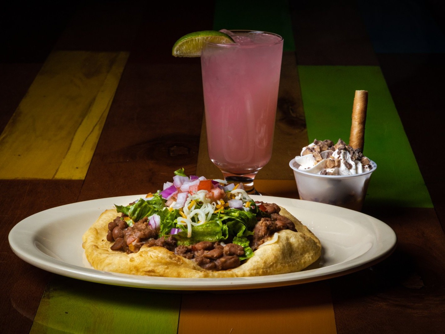 Serve Navajo taco drizzled with savory toppings, offering hearty Southwestern flavor in vibrant setting