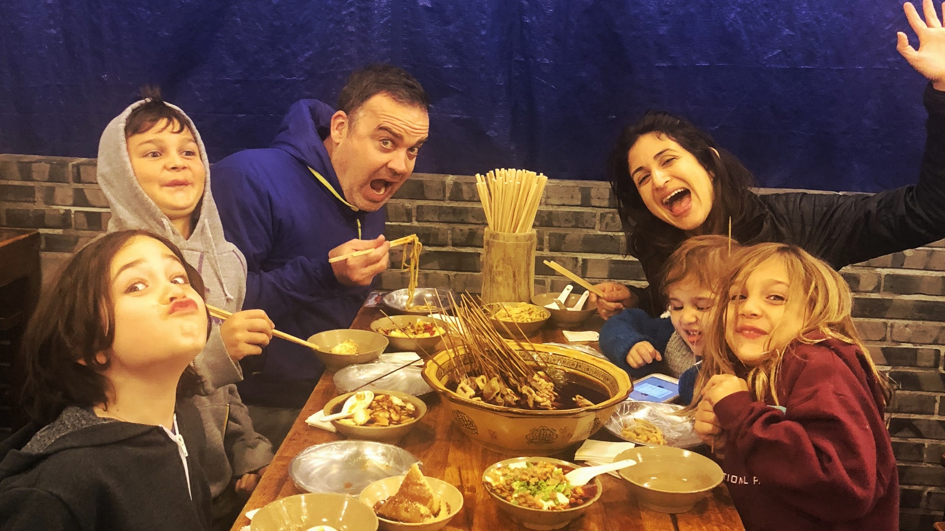 a family eating noodles and chengdu food