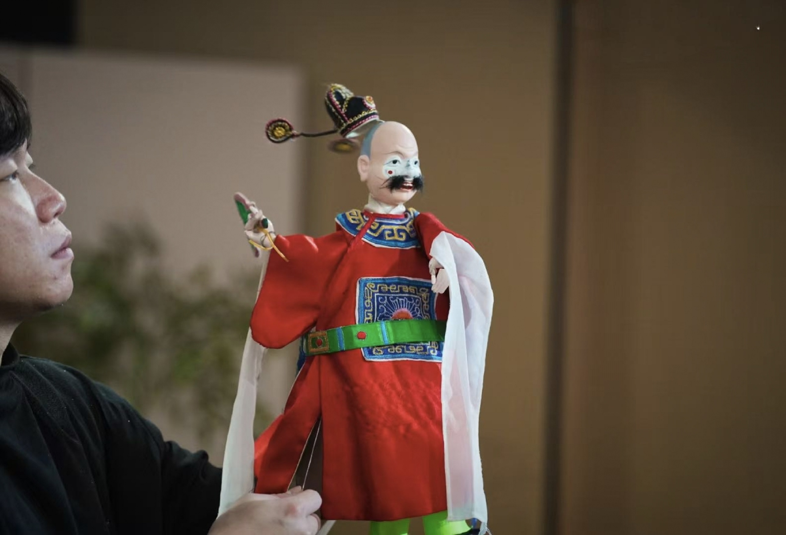 人的目光鎖著木偶的指尖，連呼吸都跟著絲線的顫動慢了半拍