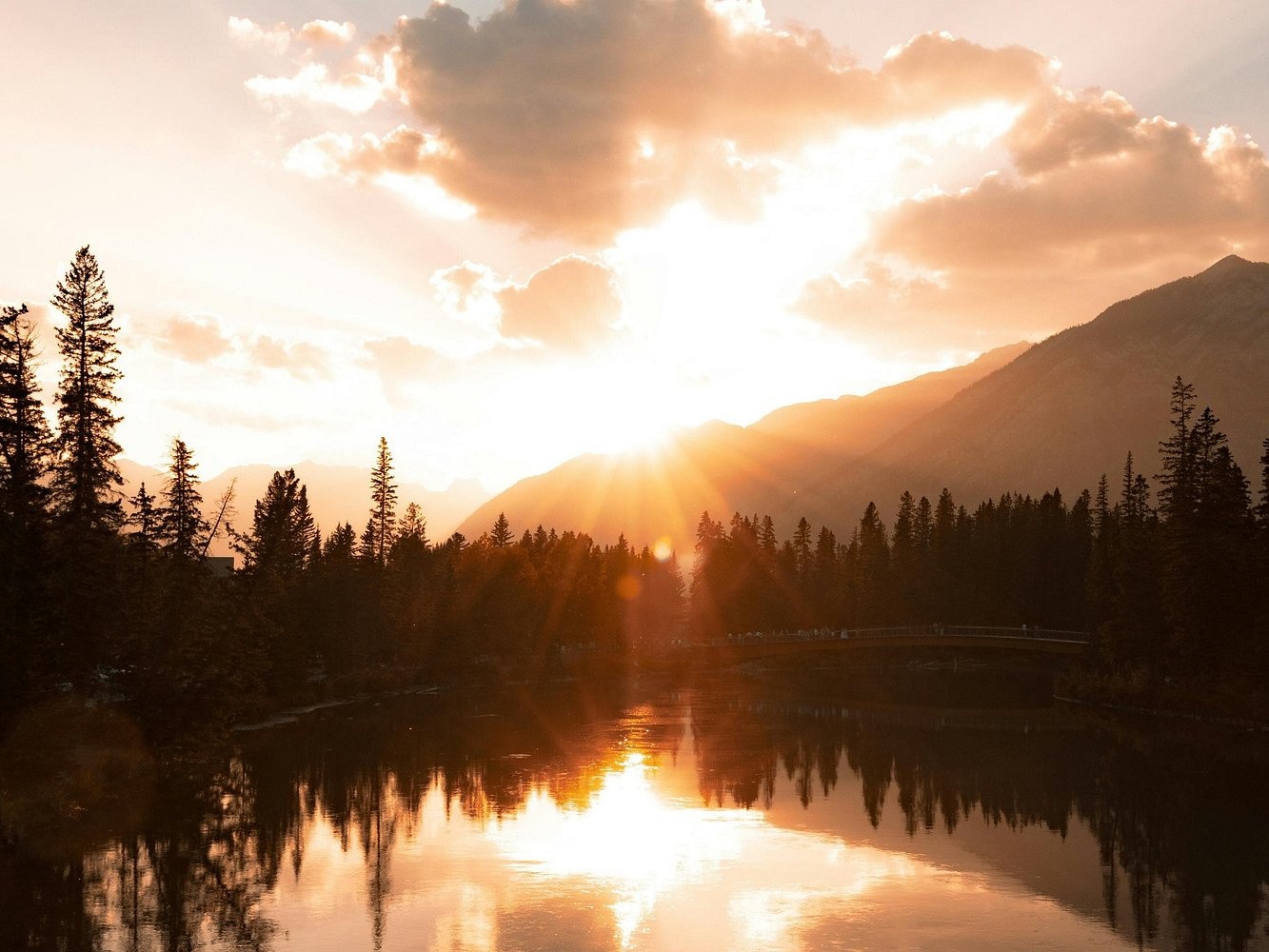 Watch golden sunlight reflect off icy waters during a peaceful Lake Minnewanka winter sunset