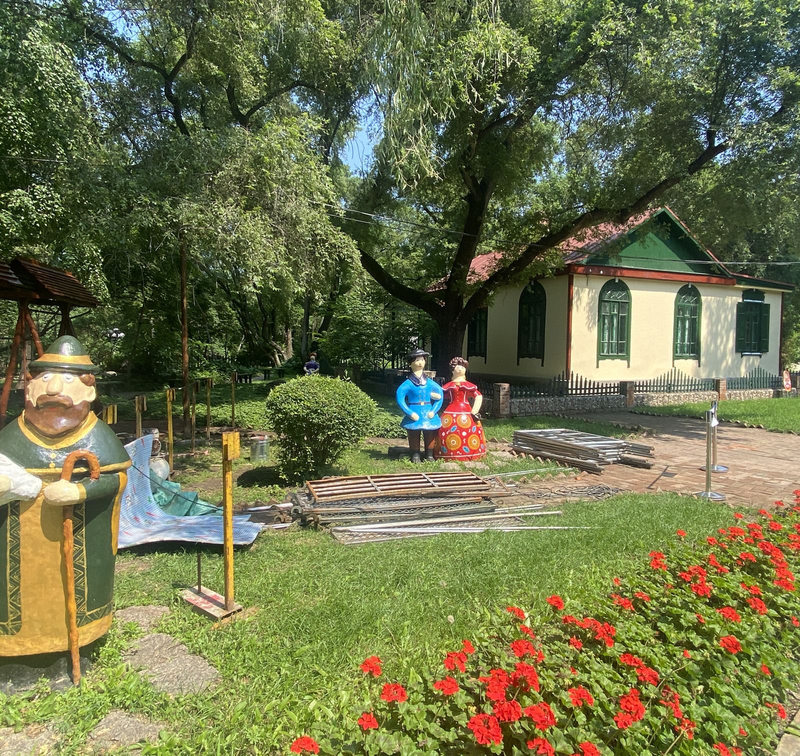 鮮花簇擁著彩色俄式小屋，小徑旁有可愛的俄羅斯風格人偶雕塑