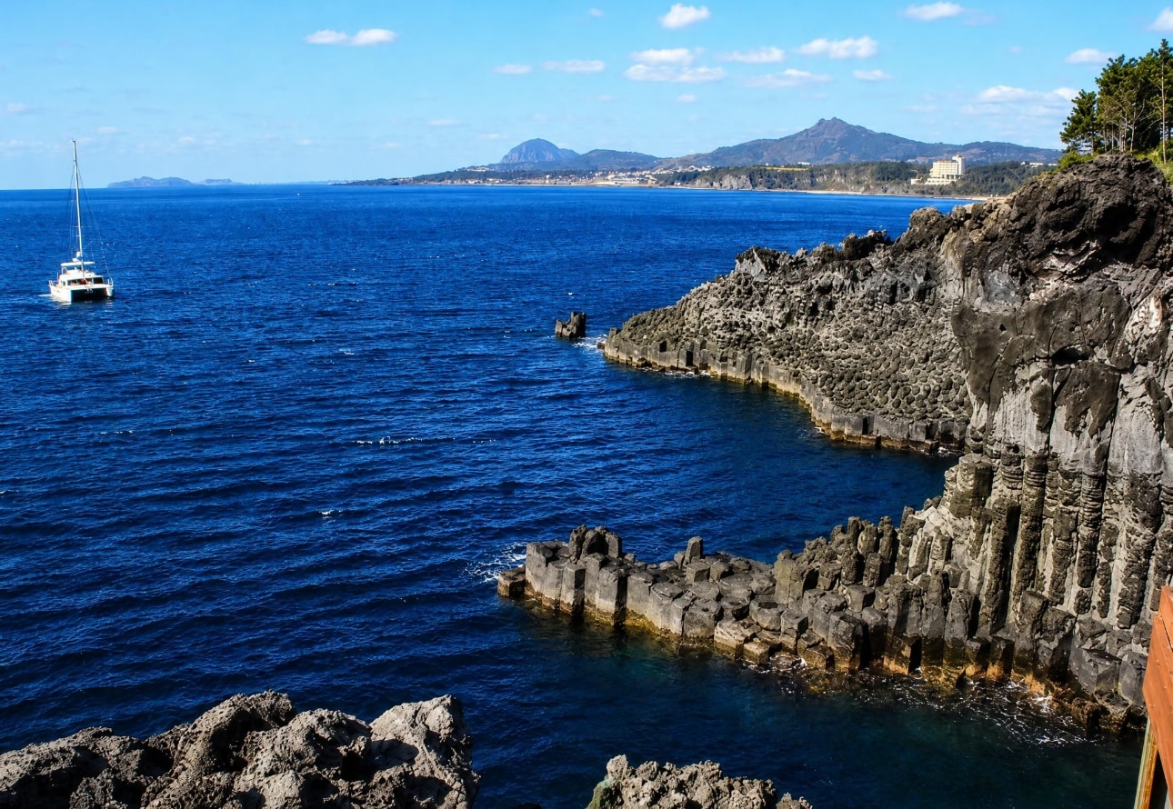 造訪大浦海岸柱狀節理帶，欣賞大自然鬼斧神工的六角形熔岩柱。感受海浪的磅礴氣勢，沉浸在濟州獨特的火山地貌中，留下難忘的精彩照片與回憶。