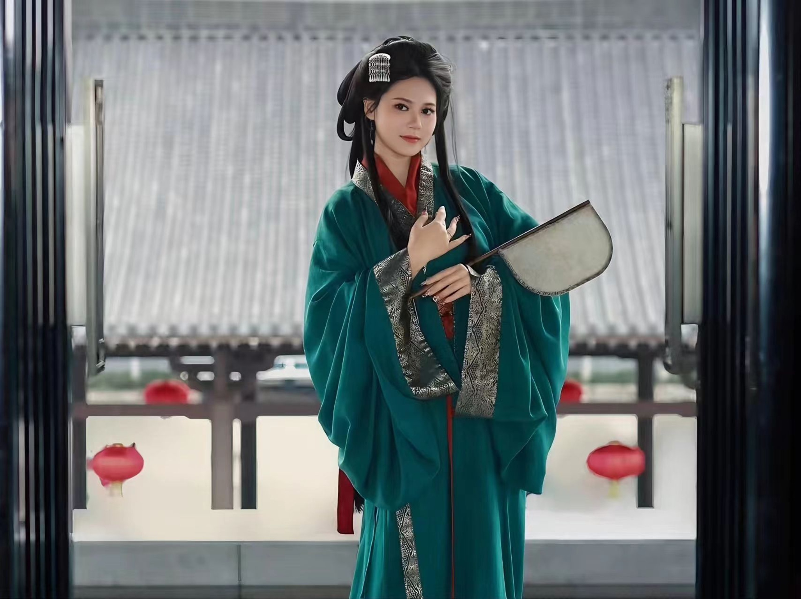 深綠曲裾配銀紋鑲邊,少女持團扇立於古建前,盡顯漢代女子的溫婉與端莊 深綠曲裾配銀紋鑲邊,少女持團扇立於古建前,盡顯漢代女子的溫婉與端莊