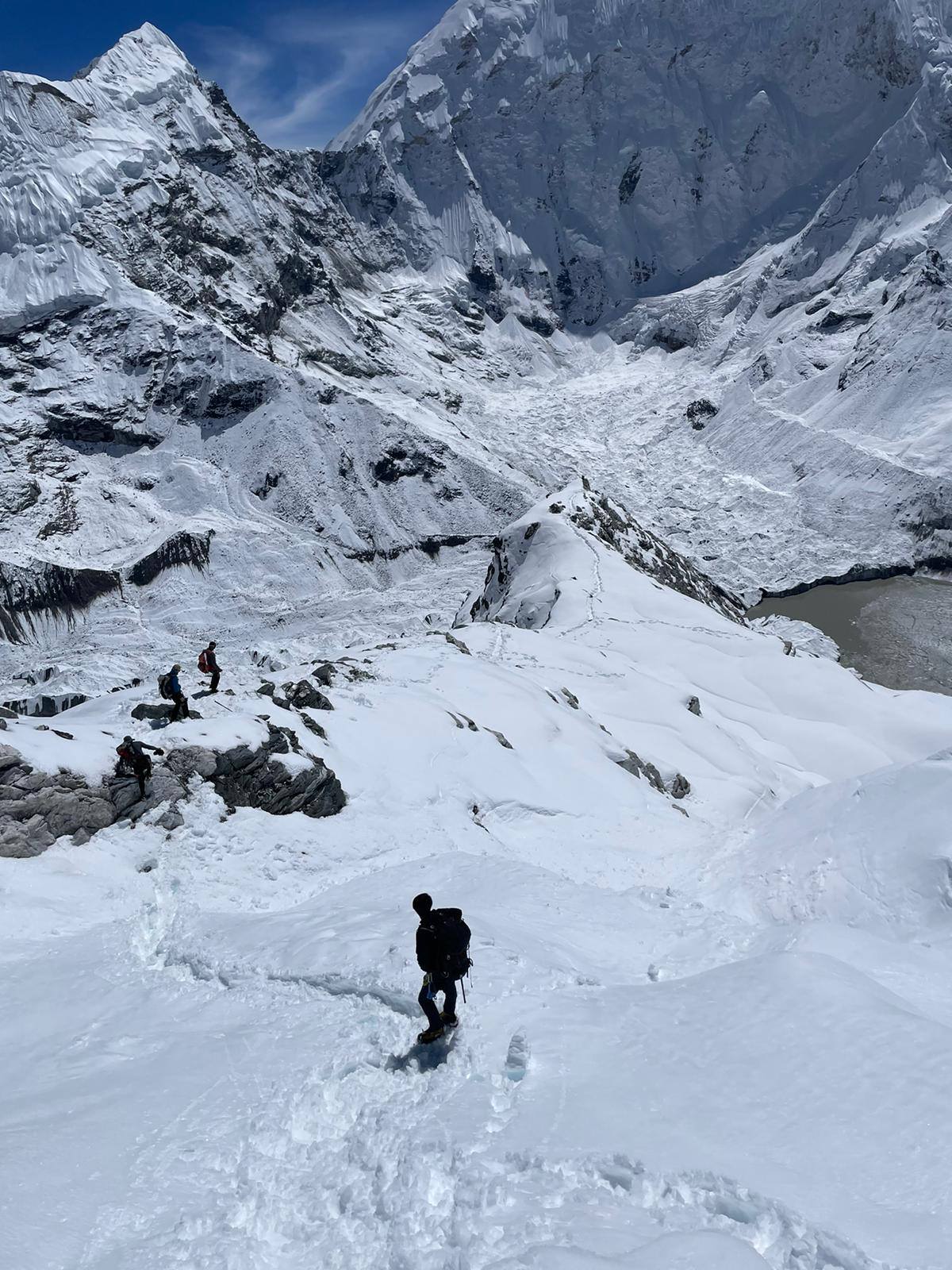 此圖片顯示人們正在聖母峰三隘口健行。 此圖片顯示人們正在聖母峰三隘口健行。