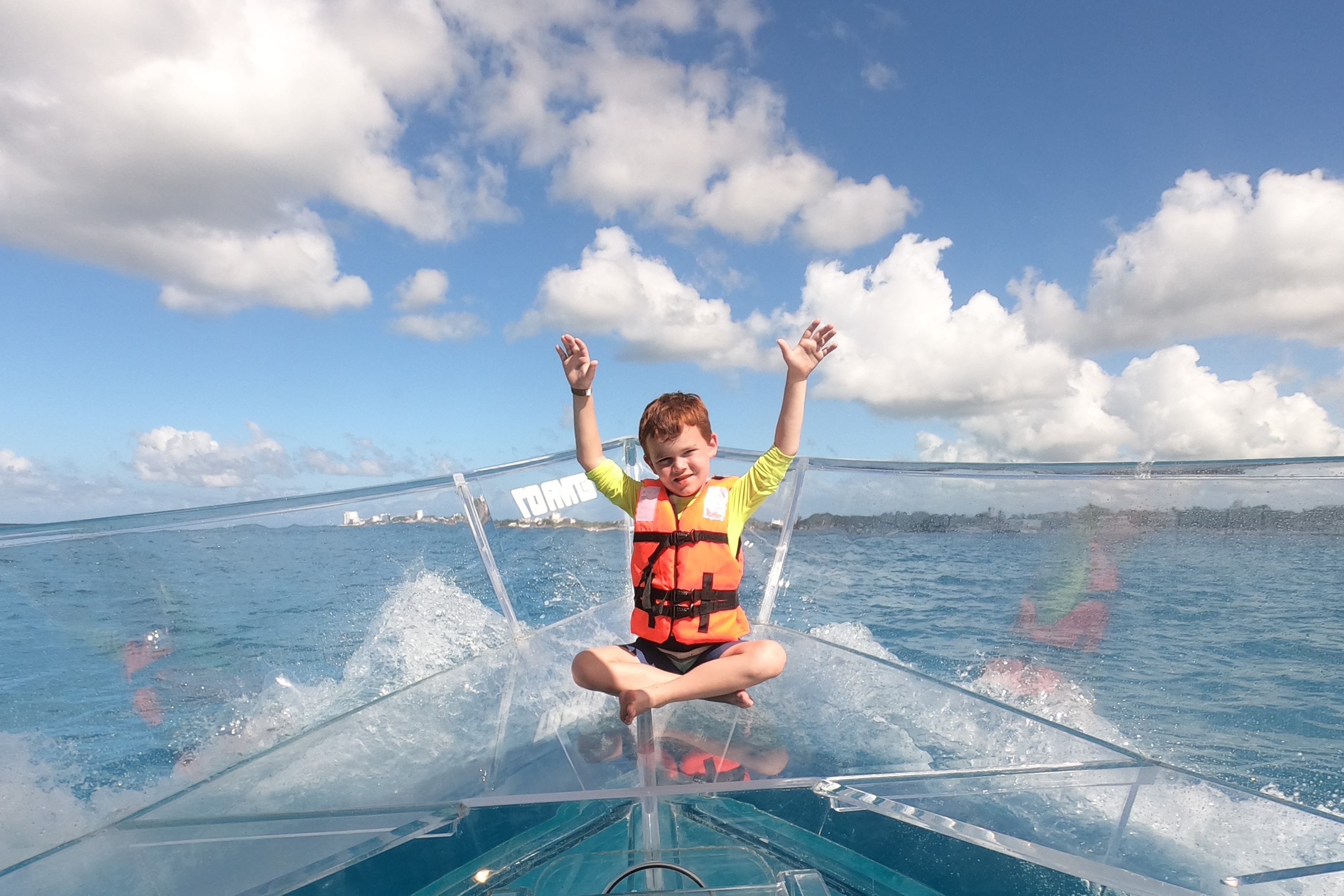 Kid grinning widely as he enjoys the boat ride