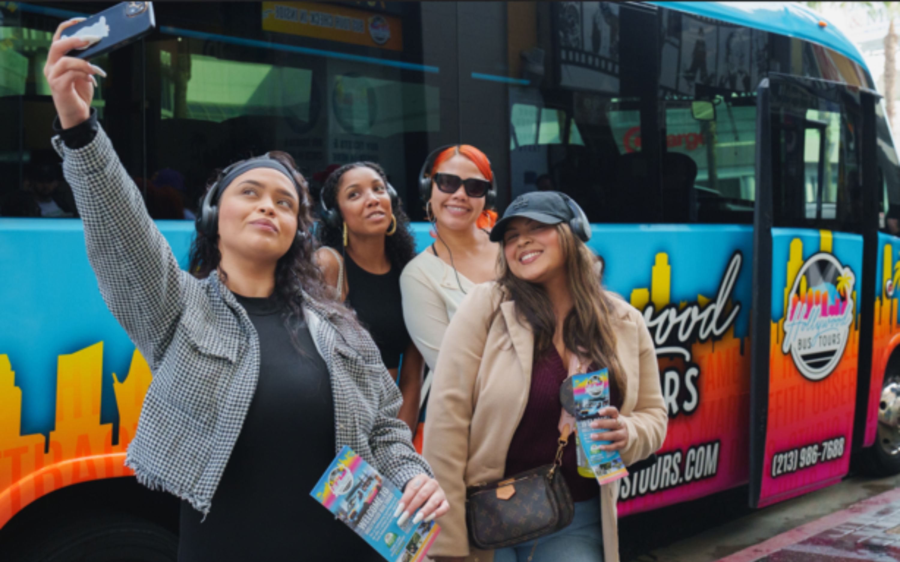 在時尚舒適的觀光巴士前拍攝團體自拍