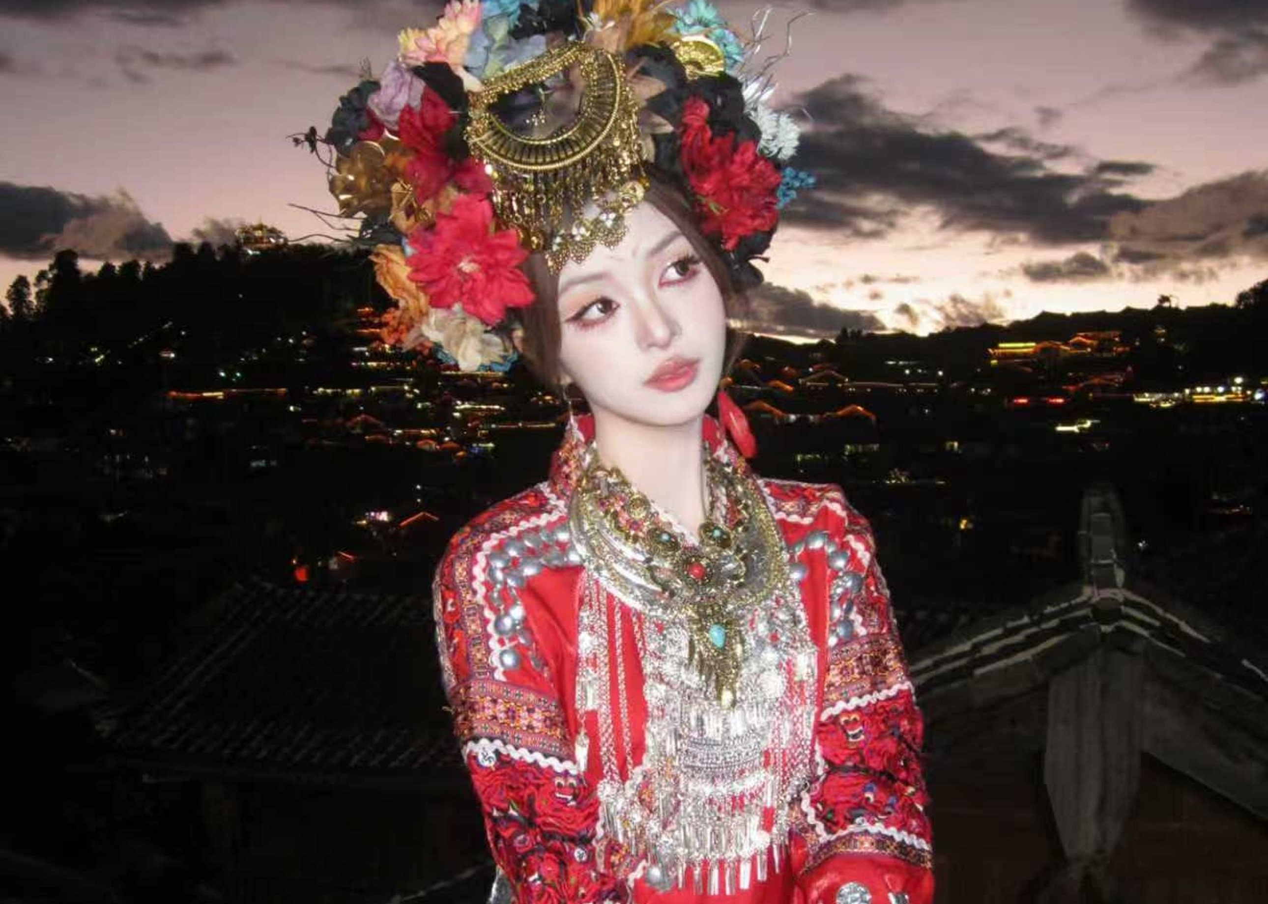 頭戴繁花與金飾交織的頭冠，紅衣上的銀飾在晚風中輕響，頸間的項鍊層層疊疊，映著天邊的粉紫霞光